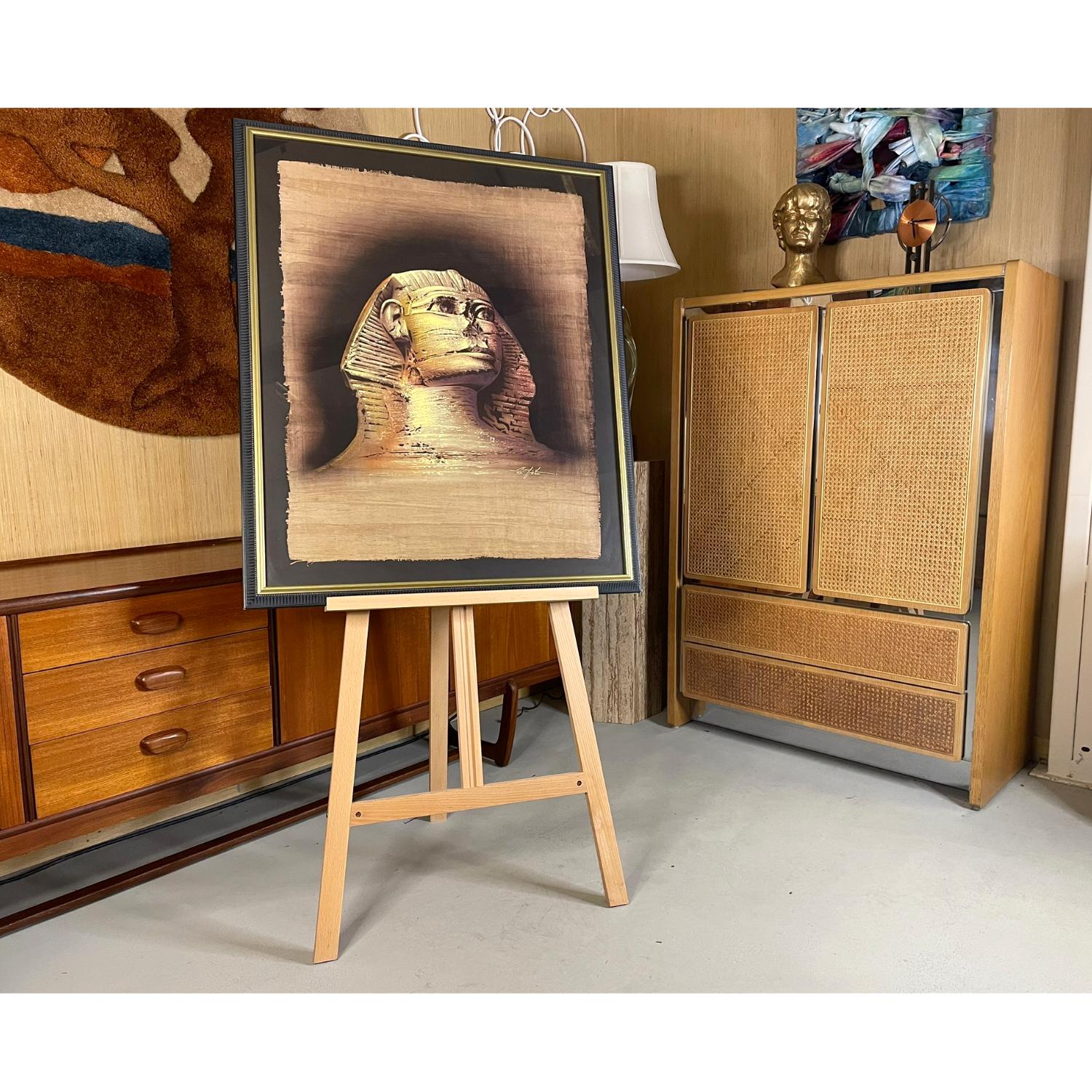 Representación mágica de la Esfinge de Guiza, en Egipto, según la interpretación del artista Monsef Labib.  Realizado a mano en El Cairo sobre papiro auténtico con intrincados detalles, este impresionismo tridimensional está aplicado en pan de oro y