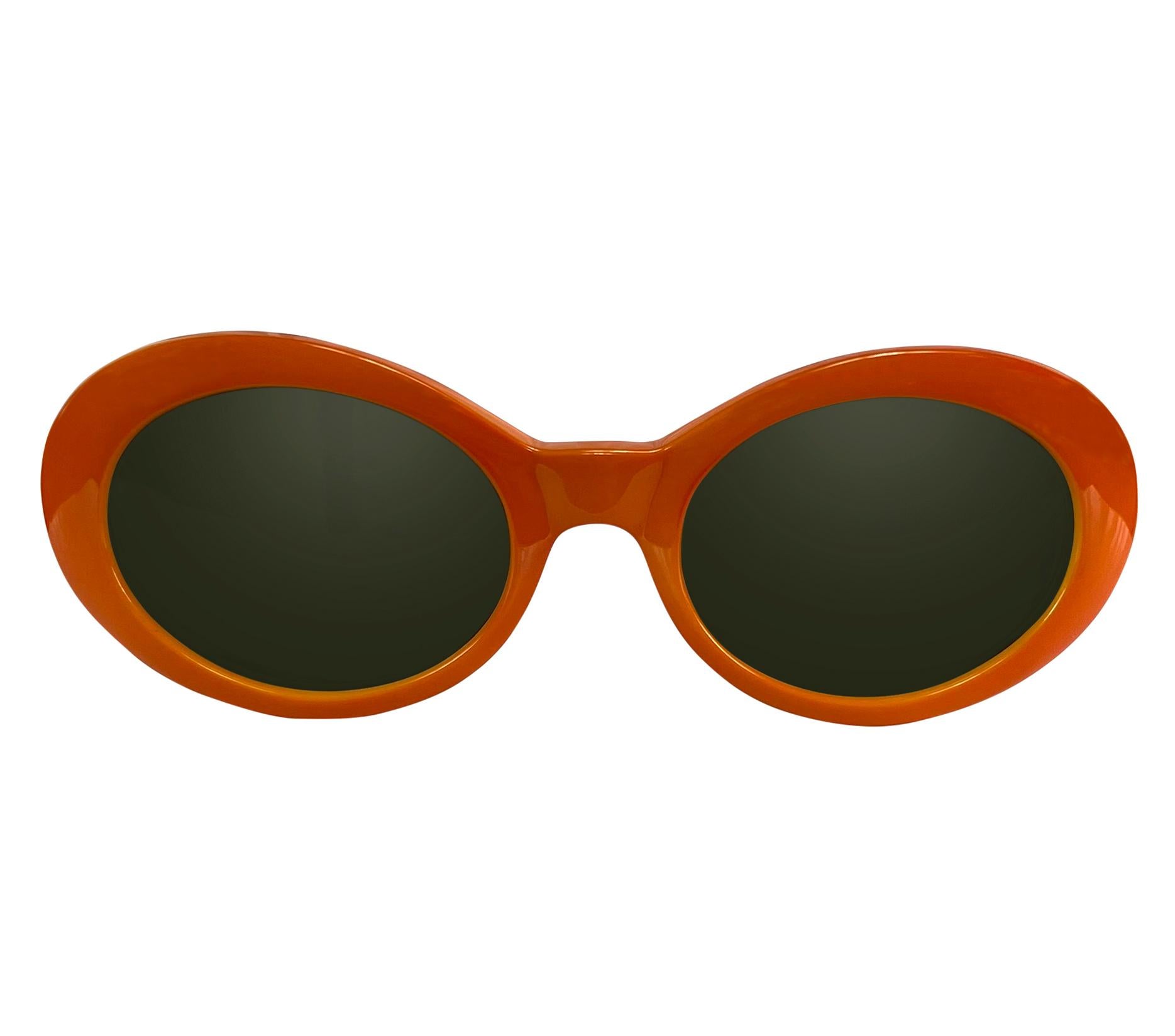Presenting a fabulous pair of vibrant orange round silver tone chain arm Gianni Versace sunglasses, designed by Gianni Versace. These ultra-rare sunglasses from 1996 feature the famous colorful round mod Versace style and are elevated with