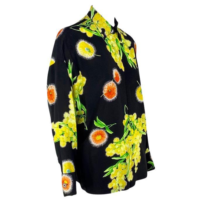Presenting a beautiful floral silk Gianni Versace Couture button up shirt, designed by Gianni Versace. Constructed entirely of printed silk, this shirt from 1996 features bright yellow and orange/red flowers a top a black background. The Versace