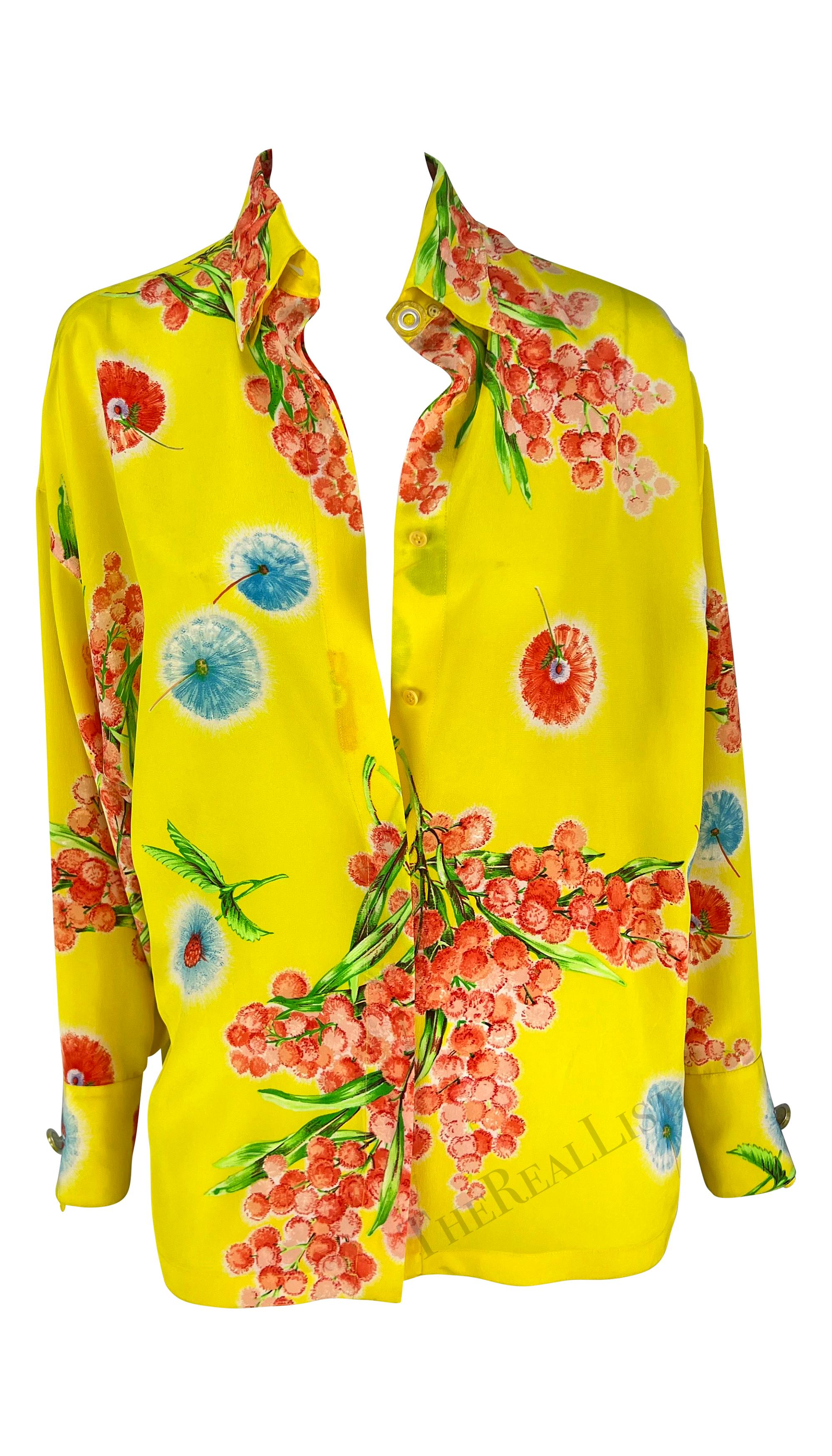 Presenting a beautiful yellow floral silk Gianni Versace Couture button up shirt, designed by Gianni Versace. Constructed entirely of printed silk, this shirt from 1996 features bright blue and orange/red flowers a top a yellow background. The
