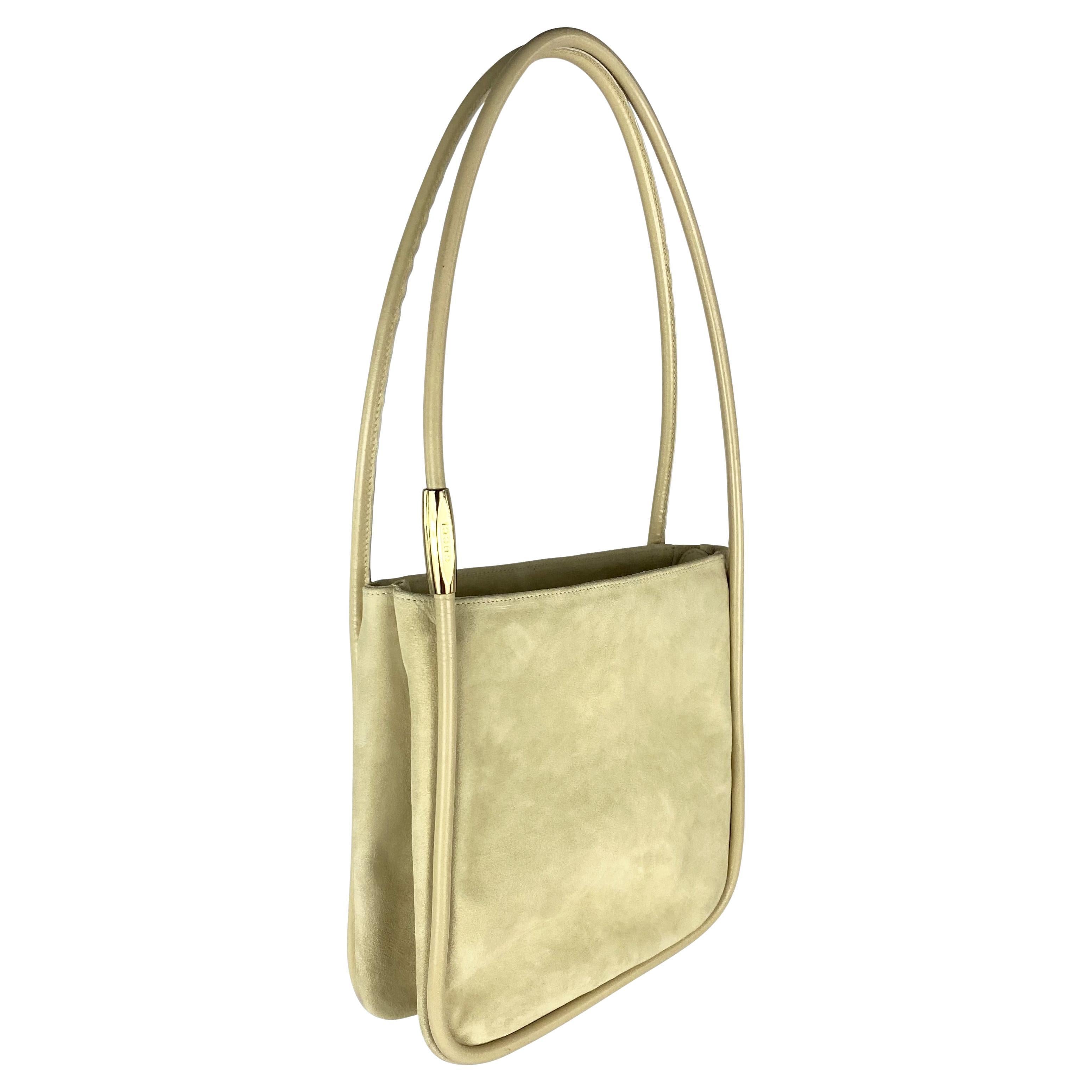 Presenting a fabulous light beige suede Gucci bag designed by Tom Ford. From the 1996 collection, this suede bag features leather piping and handles, a gold-tone accent on the strap, and is made complete with the original tags. Add this