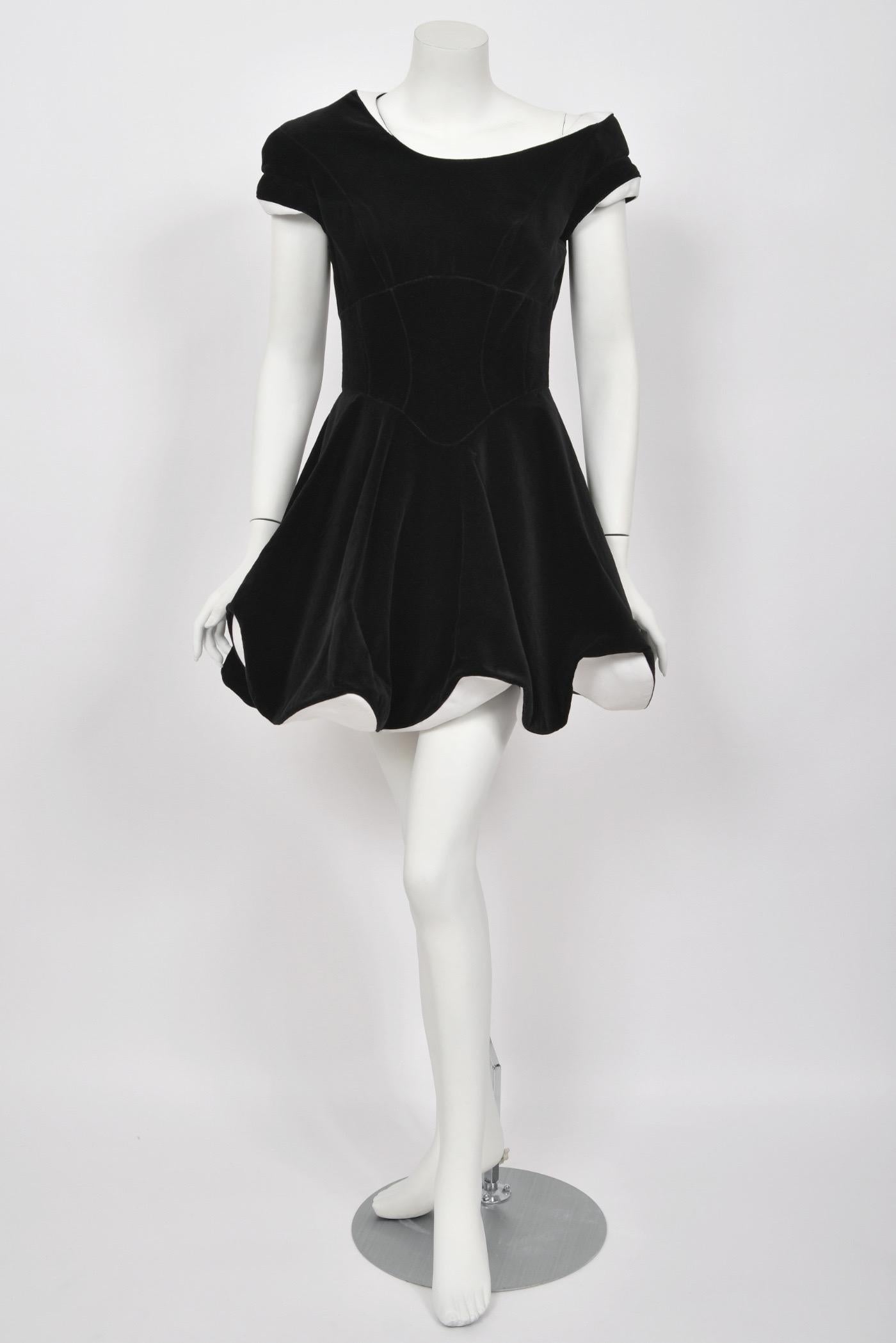 This iconic Thierry Mugler Couture black velvet white-trimmed futuristic mini dress, dating back to his 1996 fall-winter collection, is a work of art. Known for pushing boundaries with his avant-garde, sometimes theatrical creations, Mugler’s