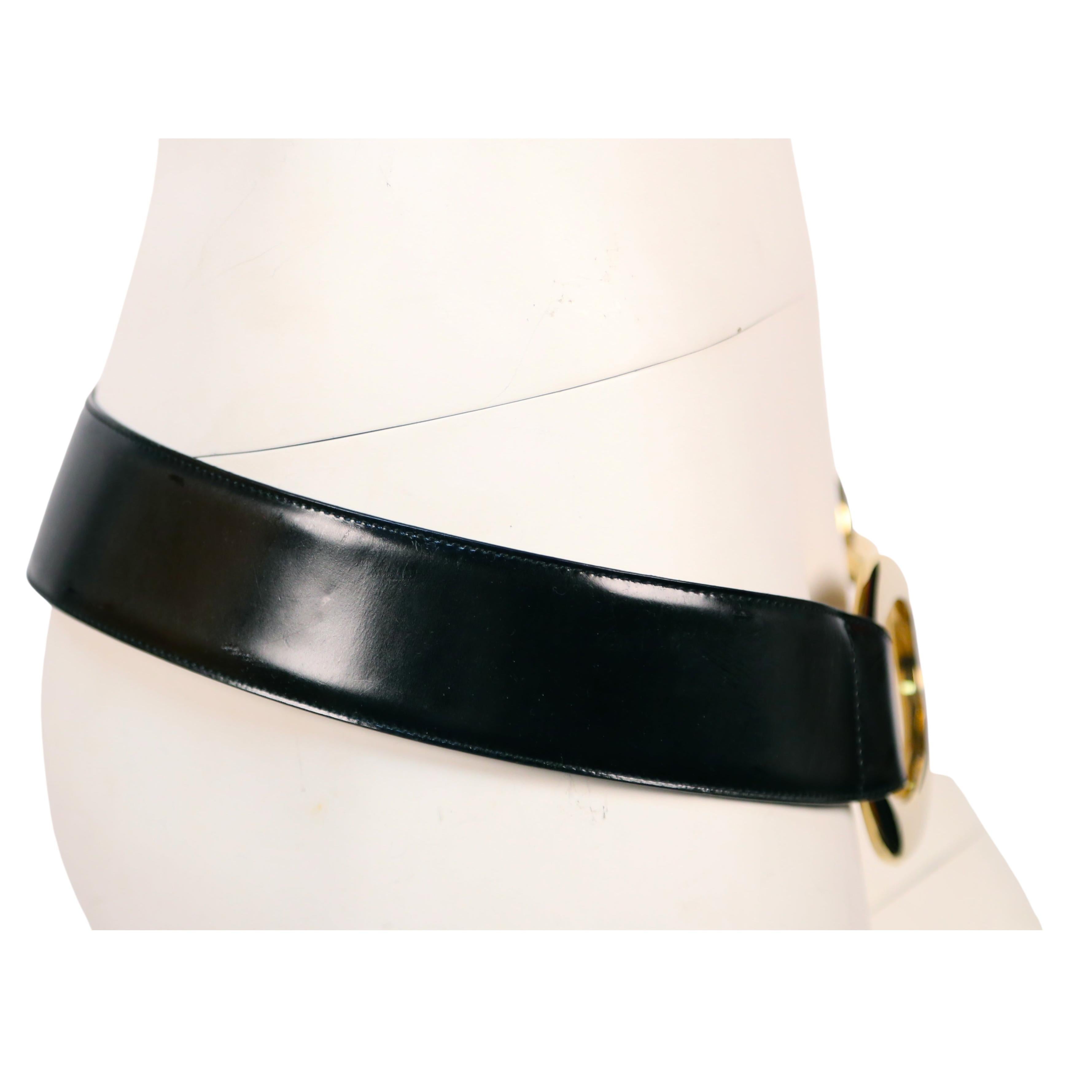 Very rare, documented, black 'spazzalato' leather belt with oversized asymmetrical gold tone buckle belt designed by Tom Ford for Gucci dating to fall of 1996. Labeled a EU size 95. Measures approximately 2