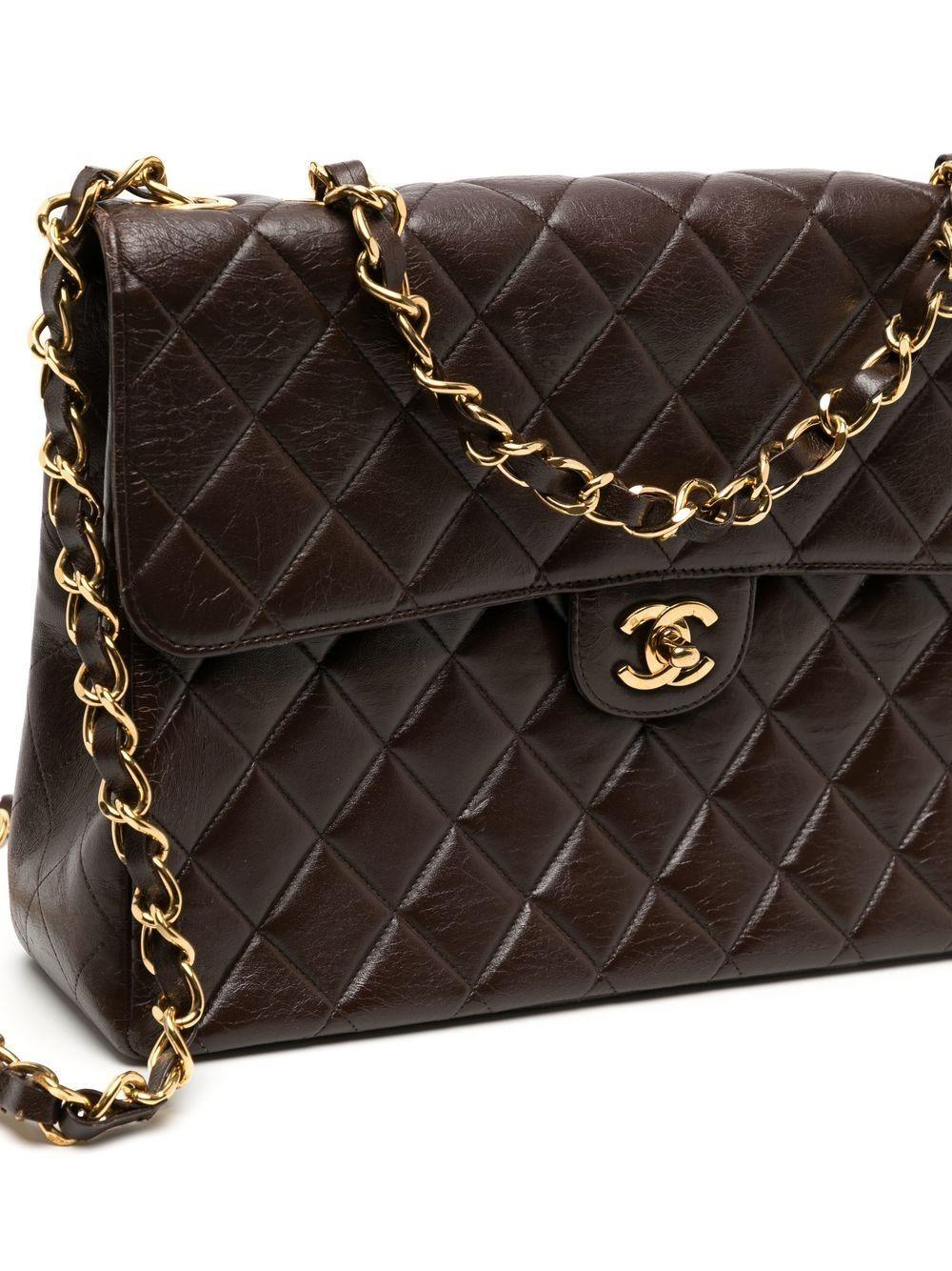 Crafted from soft lambskin leather, this Brown Quilted Lambskin Jumbo Flap from Chanel 1997-1999 features a single flap design with a white leather interior and 24k gold-plated hardware. Finished off with the signature Chanel quilting and 'CC'