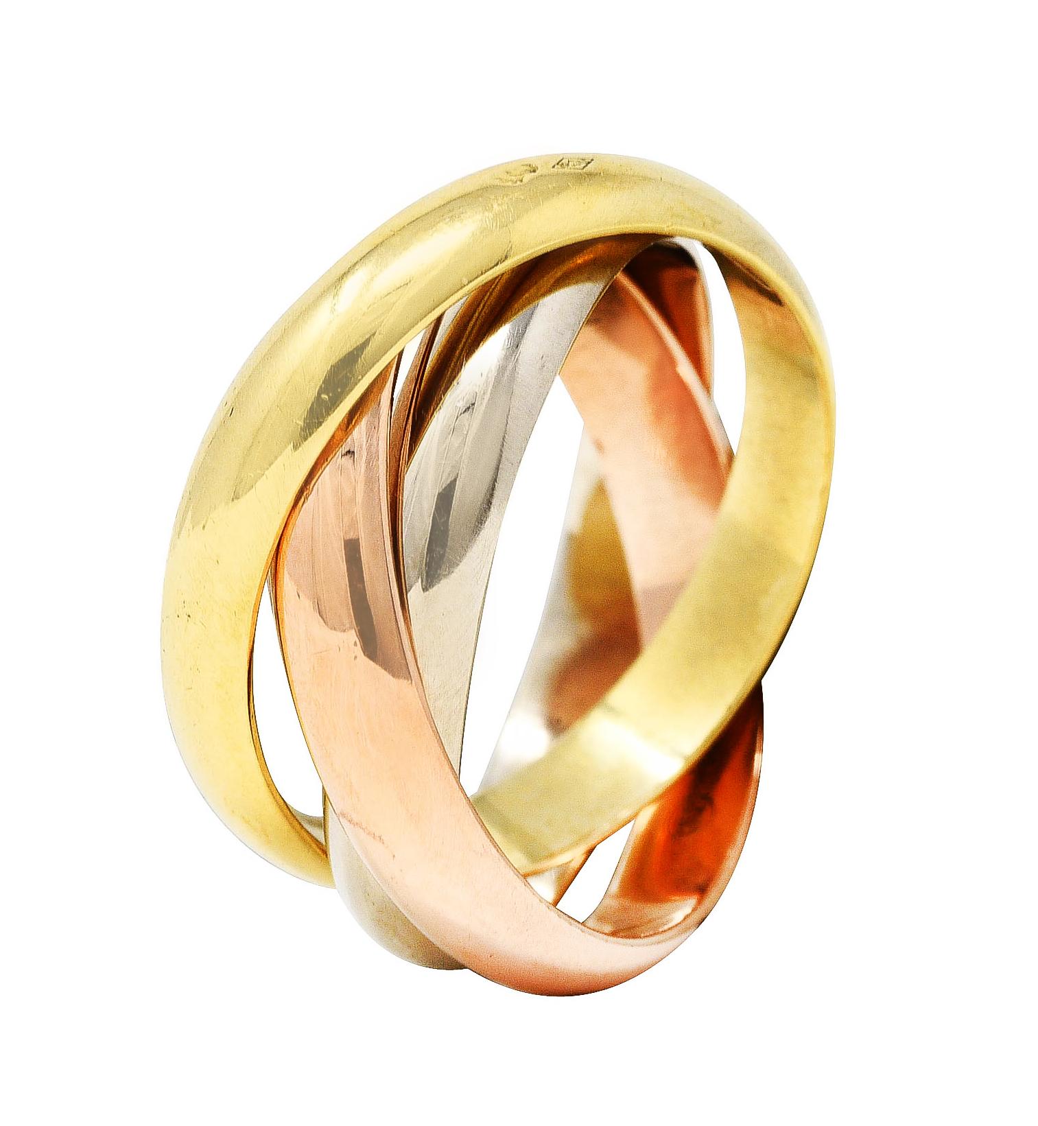 Ring is comprised of three interlocking bands of rose, white, and yellow gold

With high polished finish throughout

Stamped 750 with French assay mark for 18 karat gold

Numbered and fully signed Cartier

Circa: Stamped 1997 from the Trinity