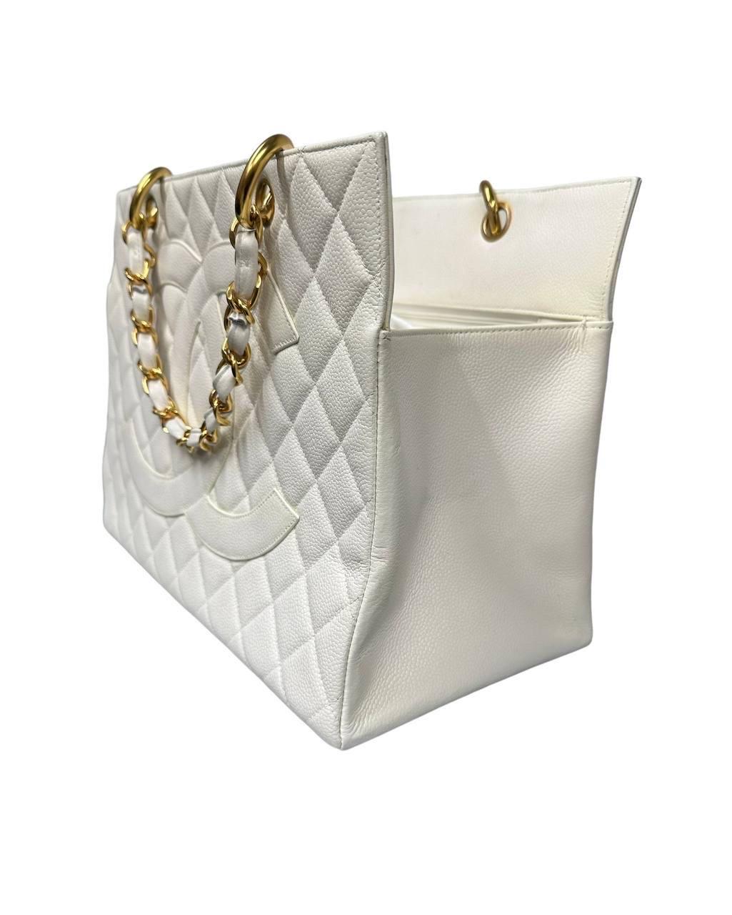 Chanel signed bag, GST model, made of white quilted leather with gold hardware. Equipped with two central handles in white leather and intertwined chain. It has a large central opening, internally lined in white leather, has two pockets with and