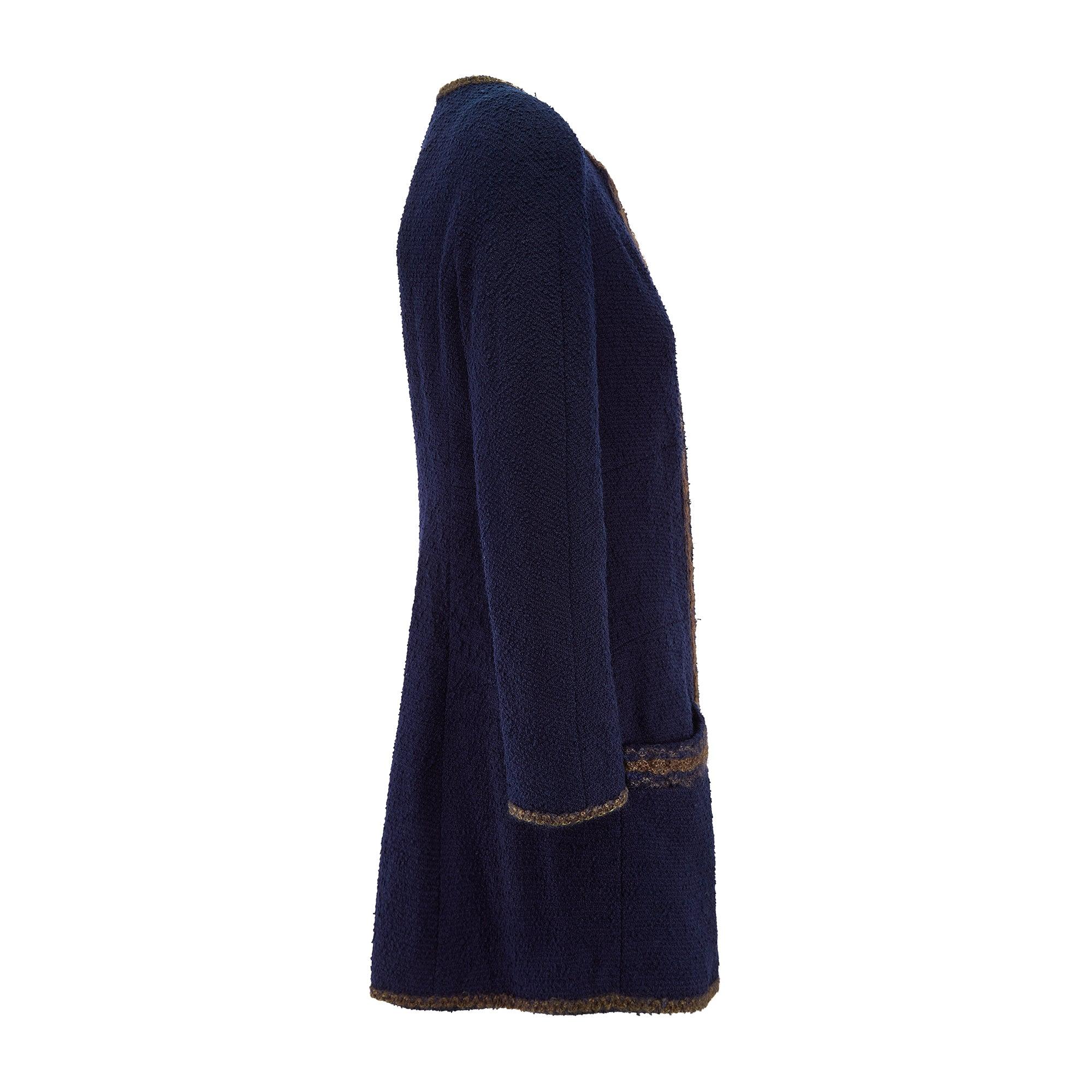 Cette veste en laine marine a défilé dans le cadre de la collection Chanel de l'automne 1997. Confectionné en laine bouclée, désormais emblématique de la maison, il présente une forme douce et souple. L'encolure sans col est élégante et le devant se