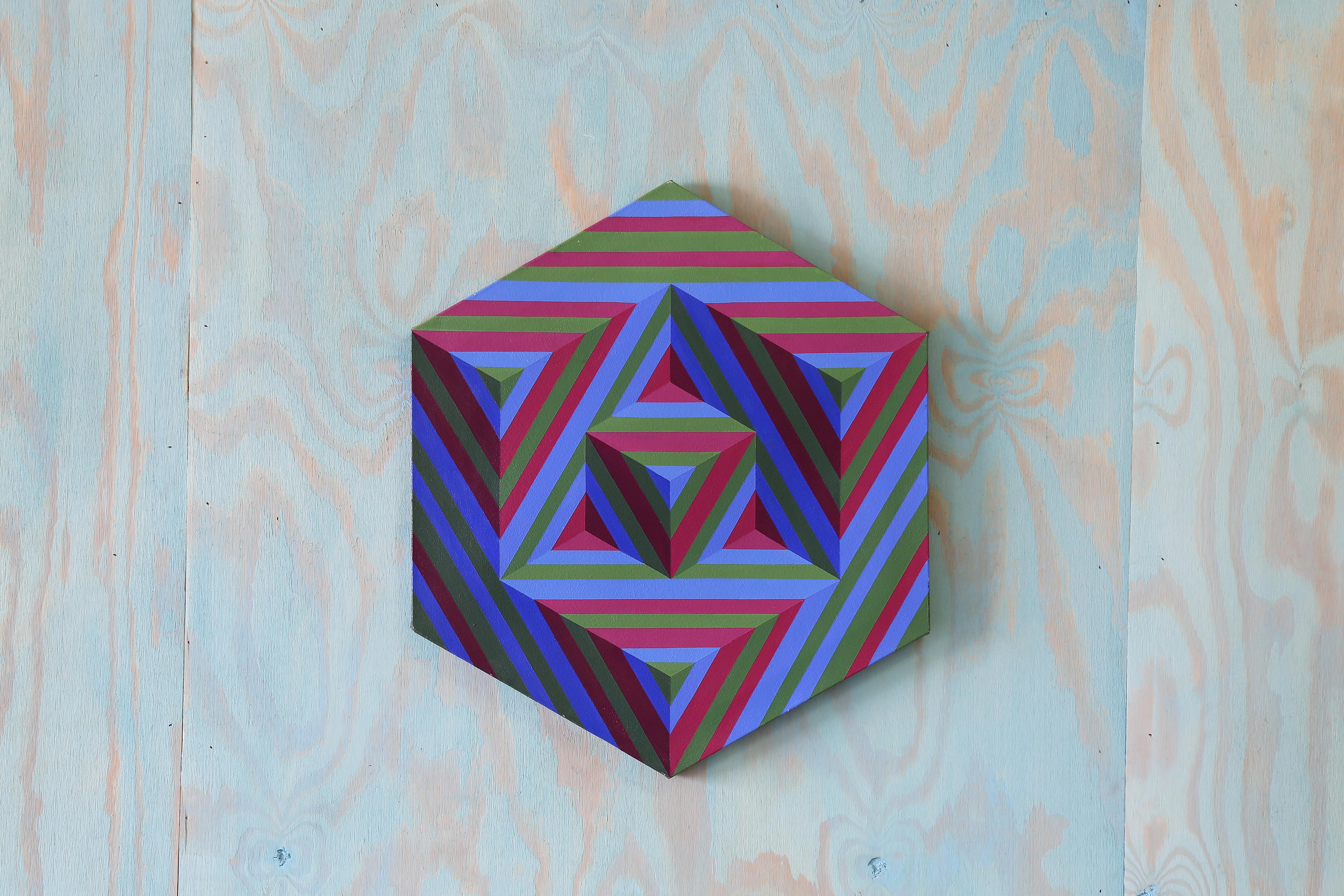 Ein einzigartiges geometrisches Op-Art-Gemälde mit ineinander verschachtelten Dreiecken innerhalb eines Sechsecks. Kräftige blaue, grüne und rote Streifen wechseln sich in der Richtung ab, um Tiefe und Bewegung zu erzeugen und erinnern an den Stil
