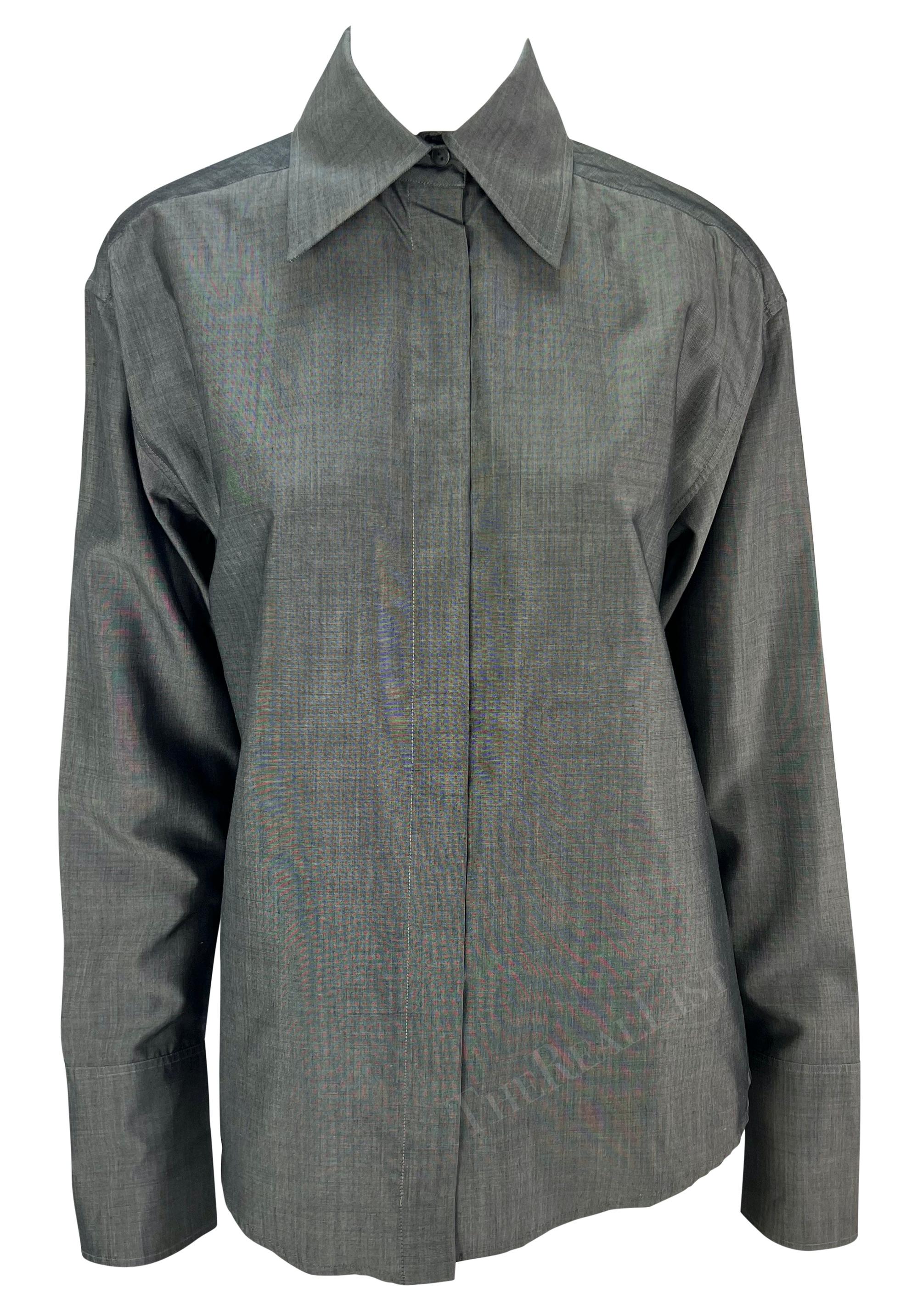 TheRealList presents: a grey Gucci button-up shirt, designed by Tom Ford. From 1997, this chic grey silk top features a hidden button closure down the front, a slightly oversized fold-over collar, and lightly bell-shaped cuffs. Whether paired with