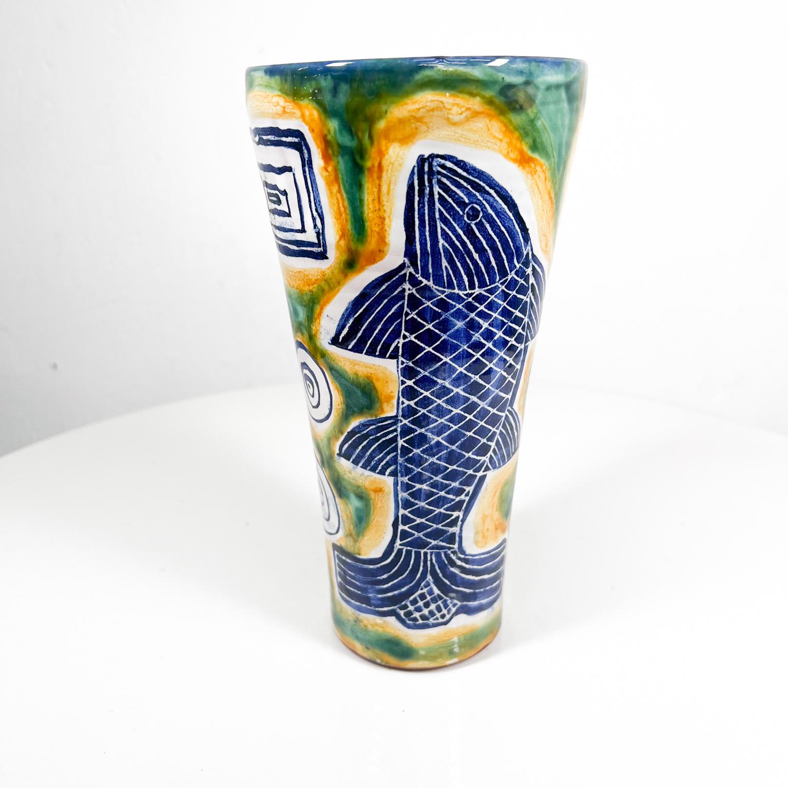1997 Modern Blue and Green Fish Pottery Vase 
8.75 H x 4.5 diameter
Hand painted colorful fish design.
Signed at bottom. M M 97
Preowned vintage condition.

See all images please.

