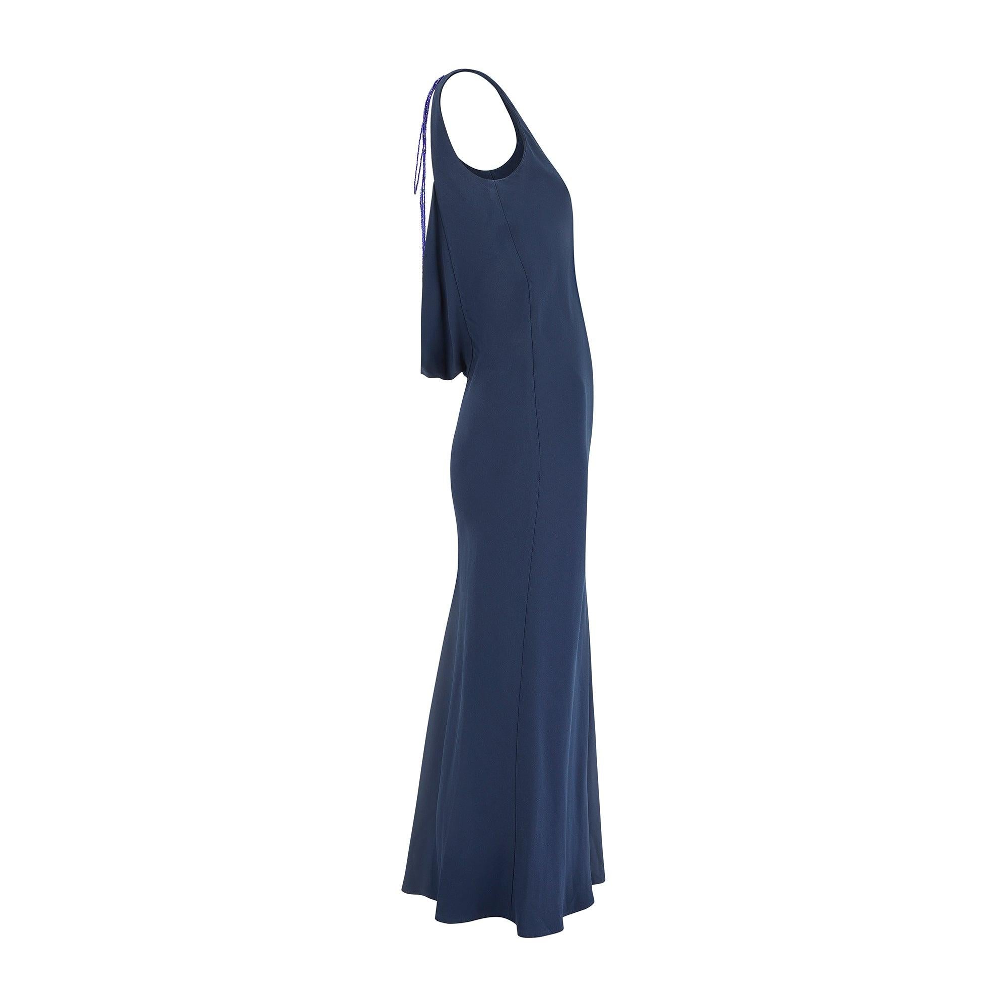 Este vestido azul marino se diseñó durante el apogeo de la marca en los noventa y resume el chic minimalista de los noventa; el diseño desfiló en la pasarela de la Colección Otoño/Invierno 1997. El diseñador de moda Richard Tyler dirigía una
