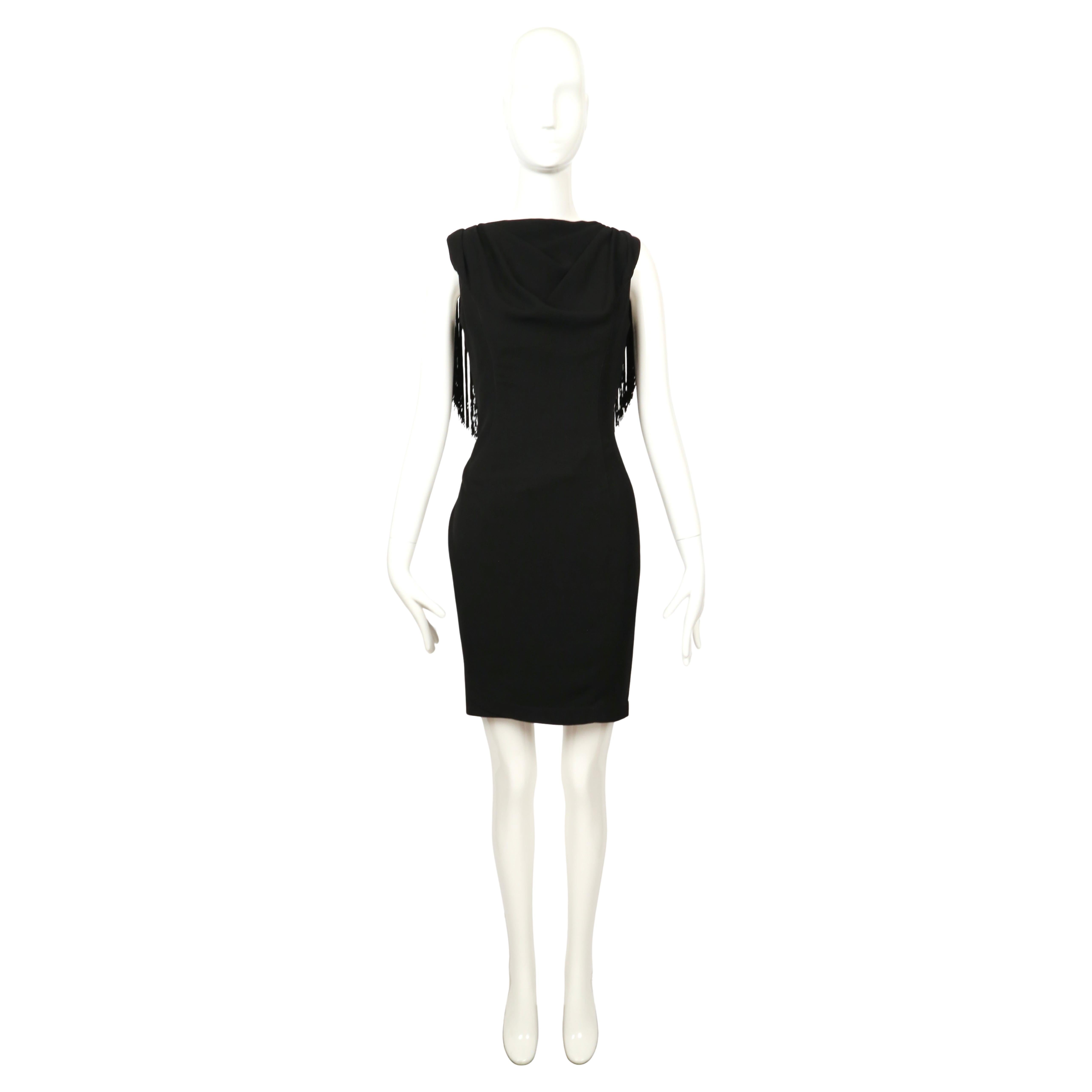 Thierry Mugler black cocktail dress from 1997. Draped and gathered to create a wrap effect around the body, the dress emphasizes natural lines while maintaining Mugler’s signature sculpted silhouette. It features an elegant bateau neckline at the