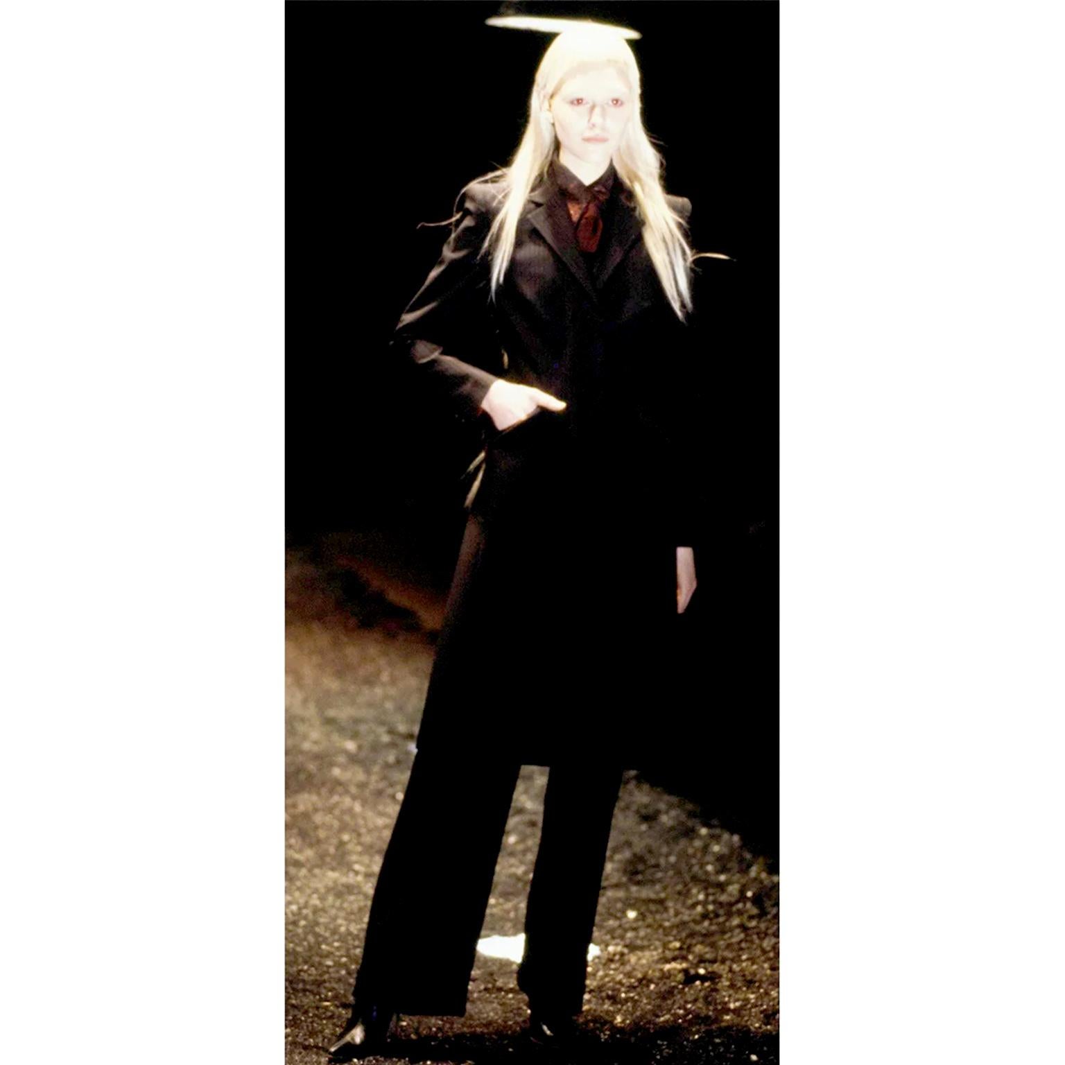 This very rare vintage Alexander McQueen black and red pinstripe pant suit that appears to have never been worn! This outfit comes from the McQueen Fall 1998 RTW Joan of Arc Runway Collection. The only photographs from the show are very dark, but we