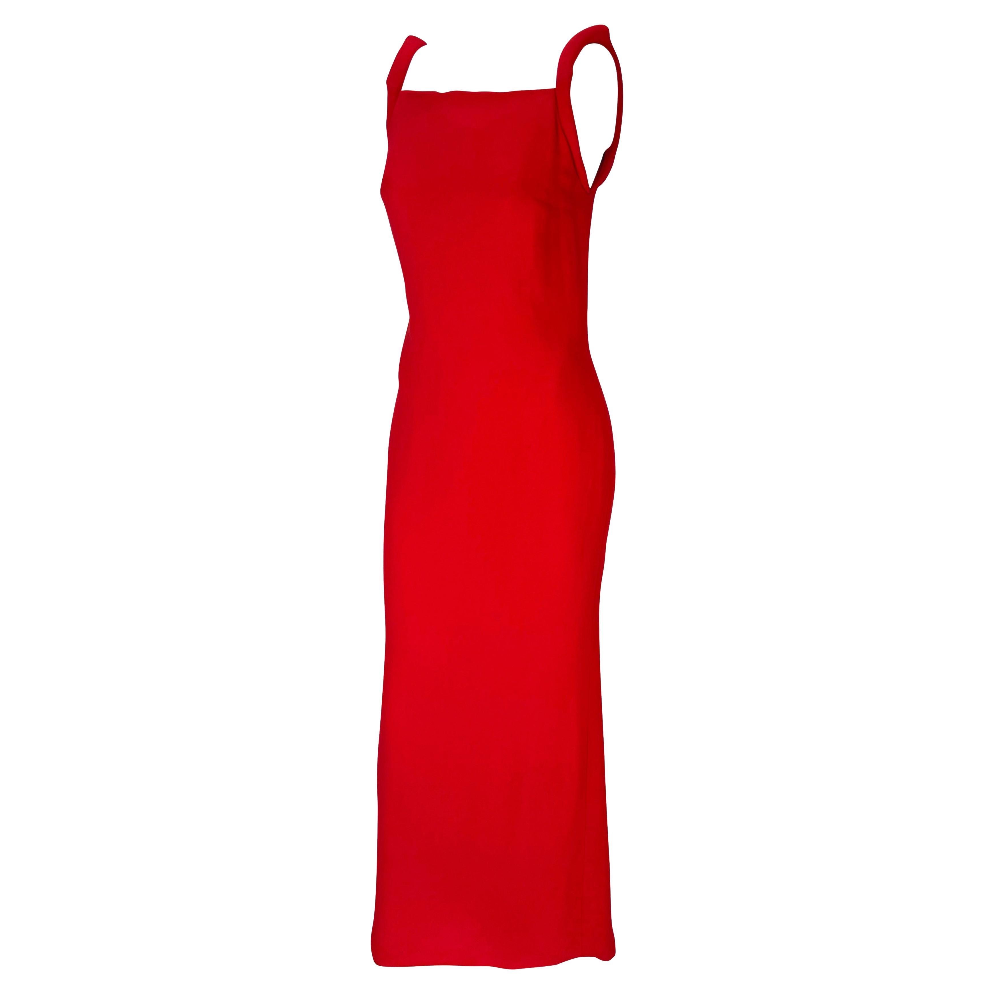Elle présente une magnifique robe rouge vif Gianni Versace Couture, créée par Donatella Versace. Datant de 1998, cette robe à colonnes présente un haut décolleté carré et un bas dos semi-exposé. Cette robe est complétée par des bretelles paddées.