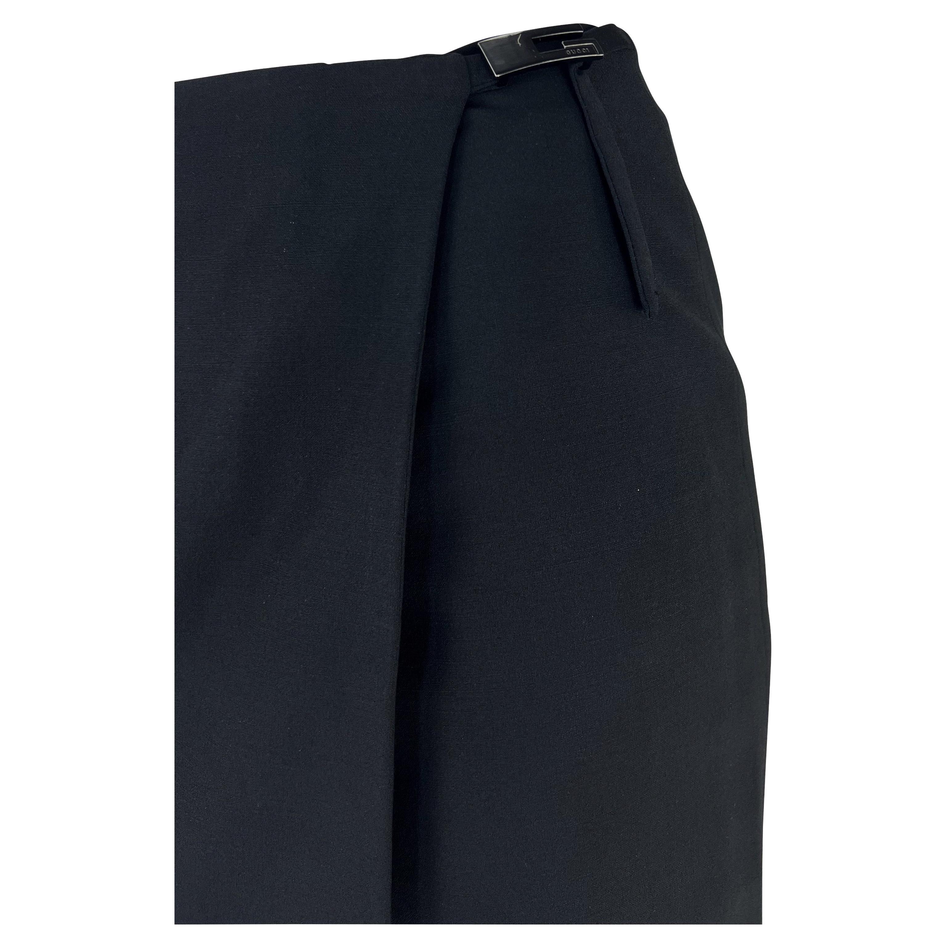 Présentation d'une fabuleuse jupe noire Gucci, dessinée par Tom Ford. Datant de 1998, cette jupe portefeuille est ornée de la célèbre boucle Gucci carrée 
