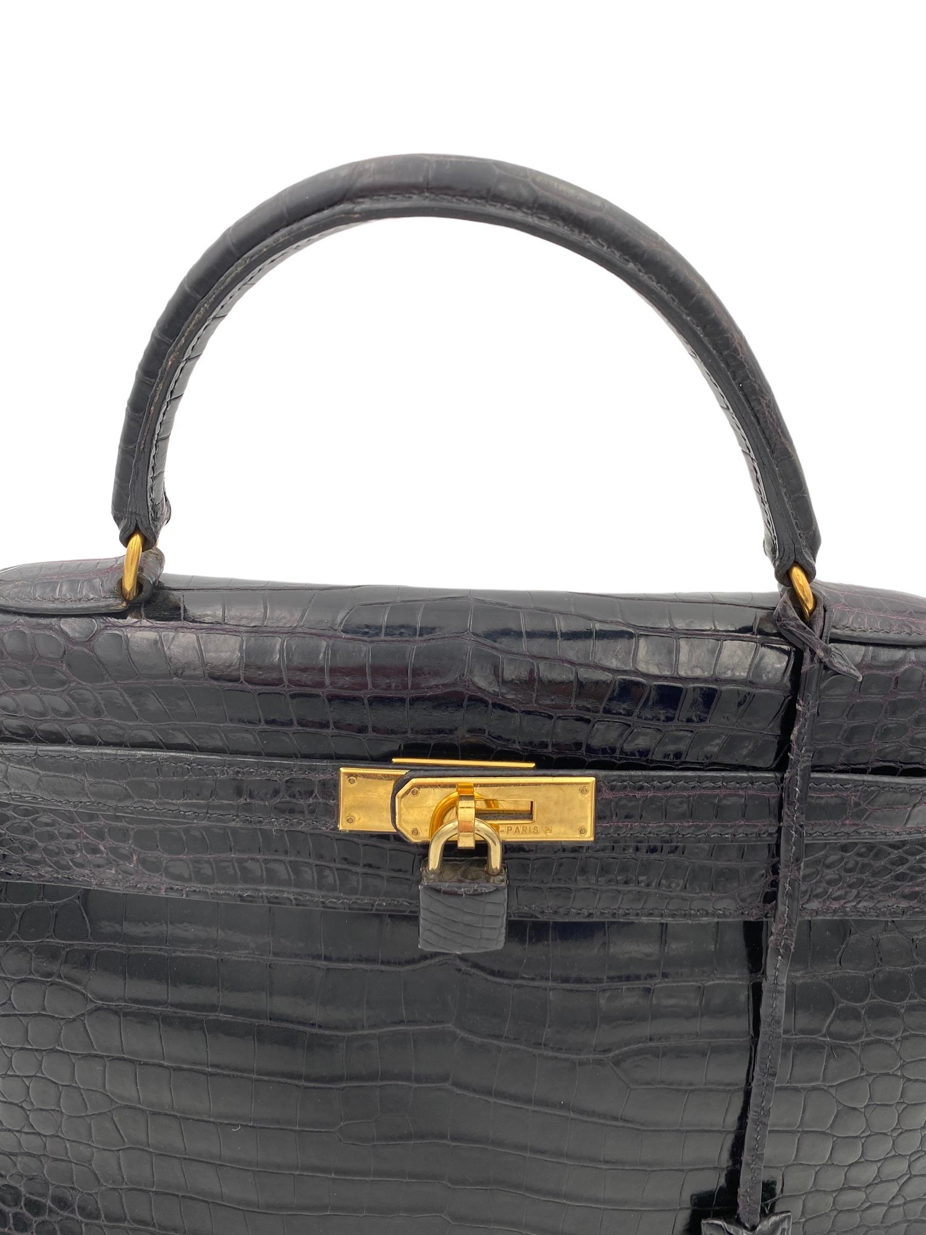 Hermès handbag, Kelly model, size 32, made in black leather with golden hardwrae. Equipped with the classic flap with interlocking closure with band, padlock and keys. Equipped with a central leather handle for hand carrying and a removable thin