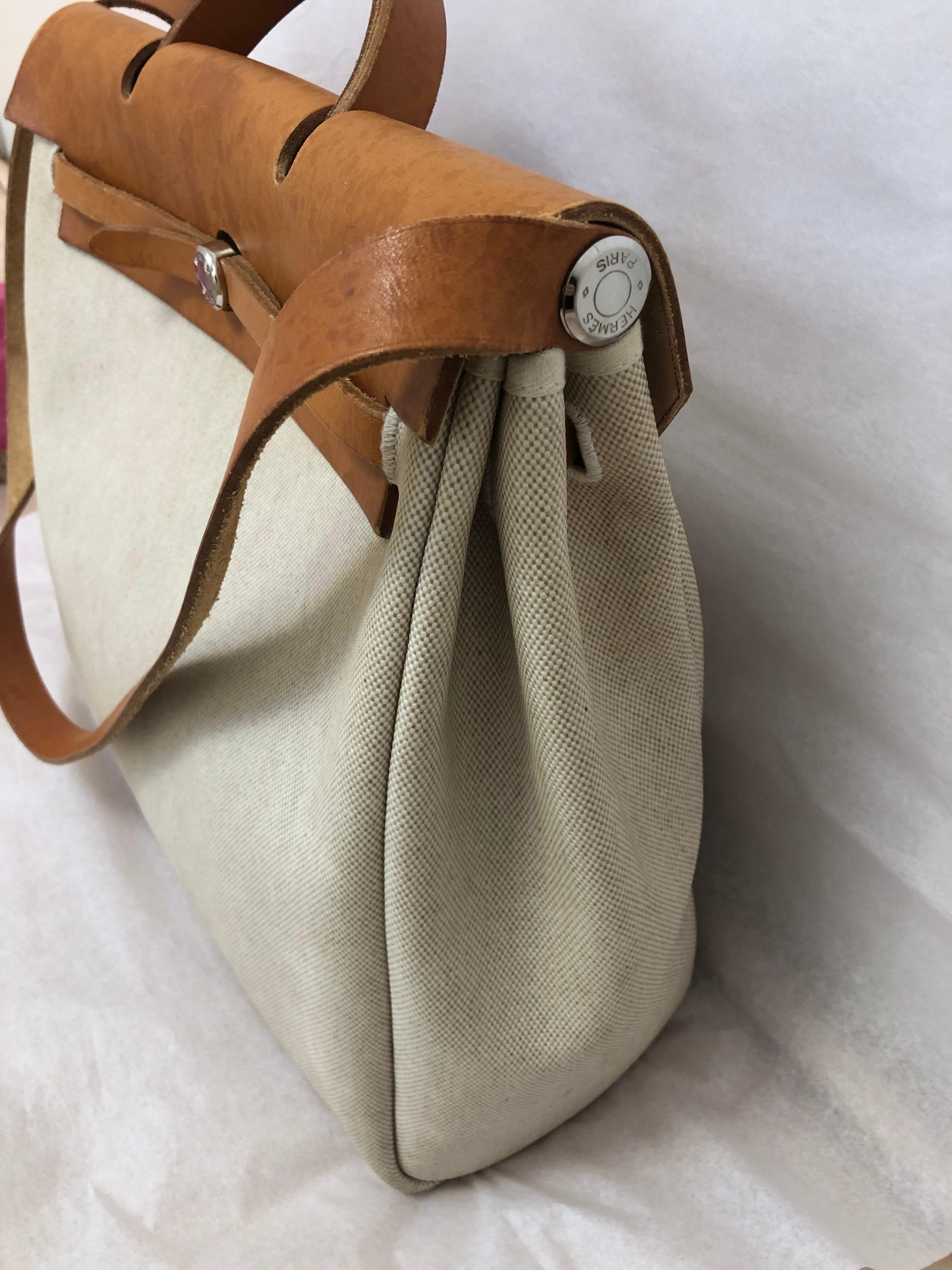 This 1998 canvas and leather large Herbag has silver hardware, lock and key, and come with the canvas protector/storage container. The bag can be carried as a handbag or crossbody, and is large enough to double up as a weekender.
It is in good