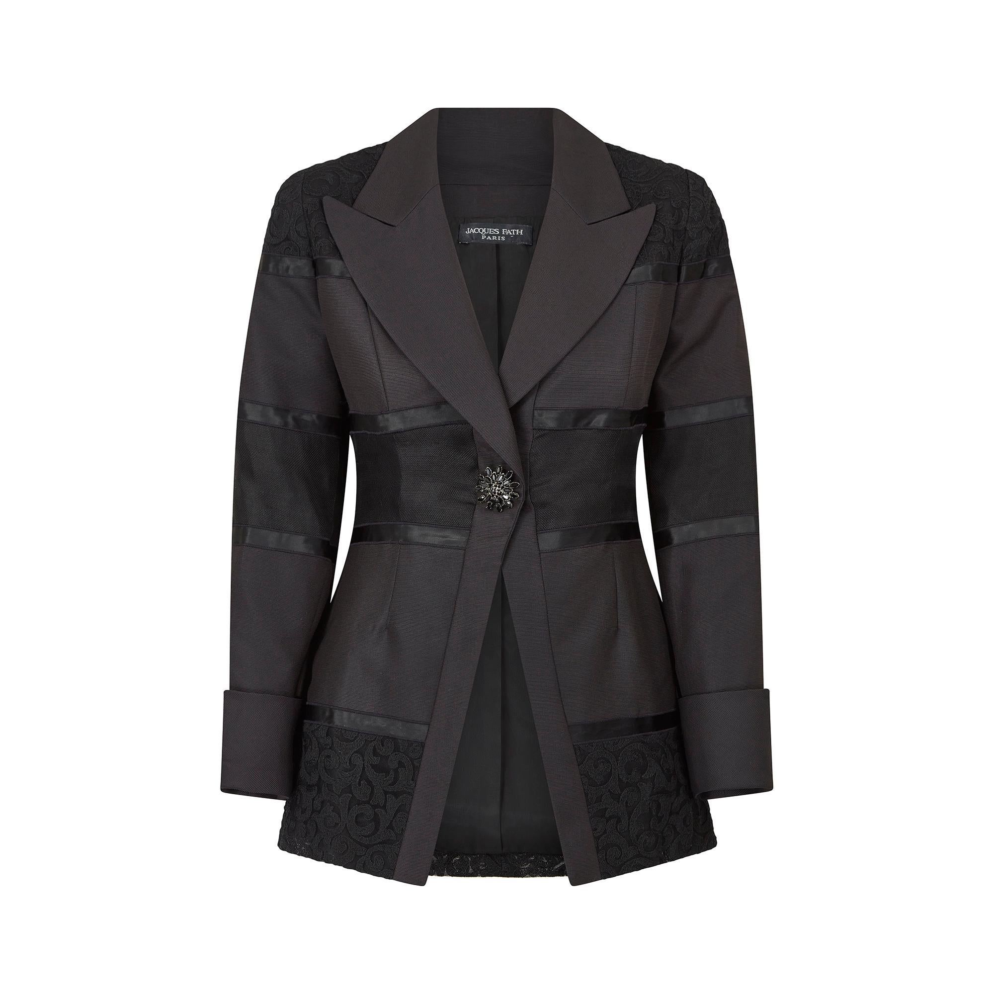 This documented Jacques Fath black cocktail jacket is from the Fall/Winter Ready-to-Wear Collection of 1998. It has wide pointed lapels and is cut from a thick woven black faille silk, with horizontal lace and ribbon panels. The shoulders, mid