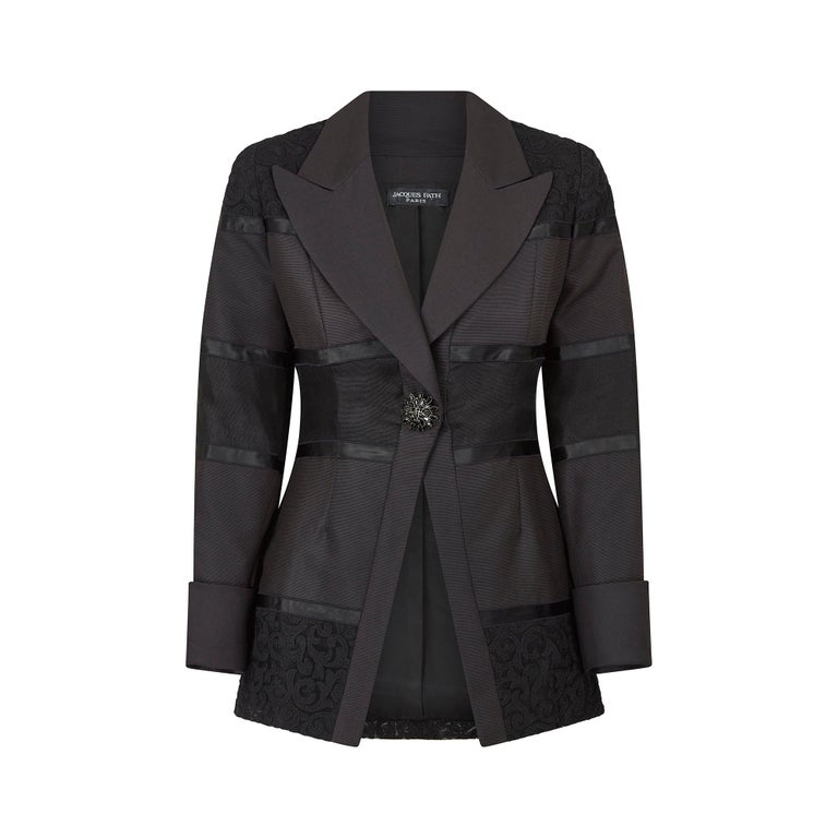 This documented Jacques Fath black cocktail jacket is from the Fall/Winter Ready-to-Wear Collection of 1998. It has wide pointed lapels and is cut from a thick woven black faille silk, with horizontal lace and ribbon panels. The shoulders, mid