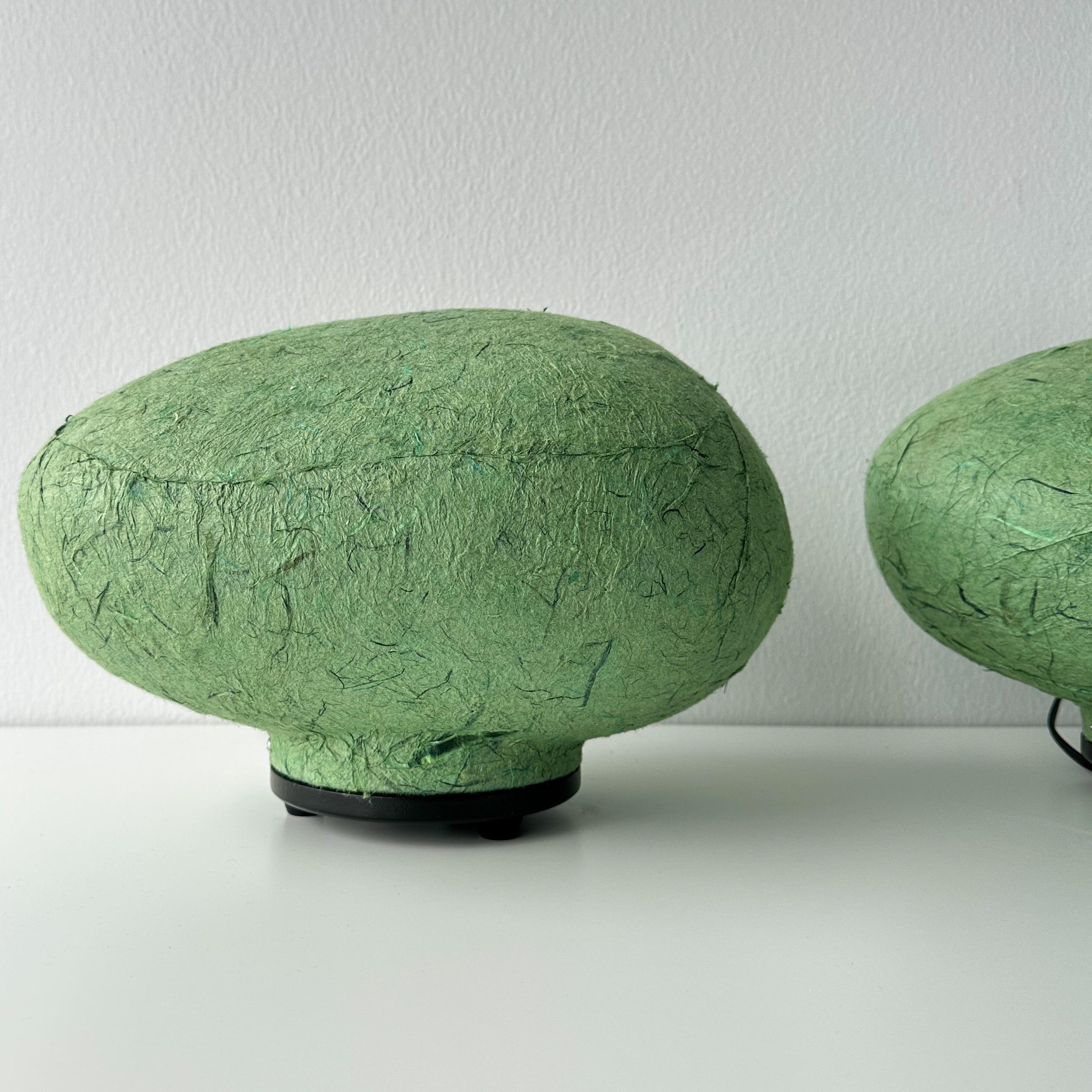Vintage 1998 Tarogo Japan paper amorphous table lamp pair. This rare pair of lamps are made from molded plastic covered in hand dyed green lantern paper. The amorphous shape of the lamps are reminiscent of stones and can be displayed facing any way.
