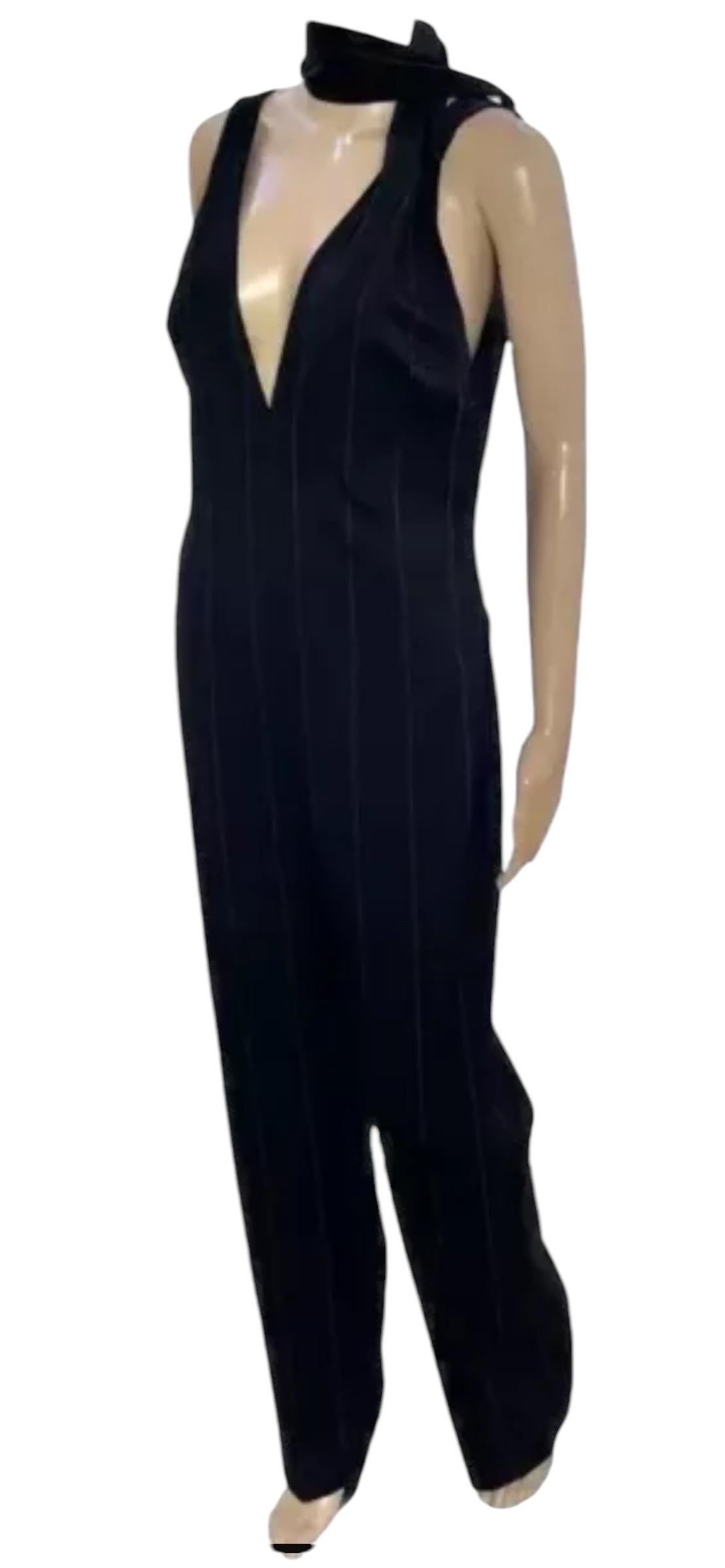 Gianni Versace Couture
Circa 1998
pinstripe jumpsuit. 
Deep V-neckOpen V-back.
Concealed zip fastening.
Content:95% wool, 4% Silk1% polyester.
Size IT 42 - US 6 
armpit to armpit 16