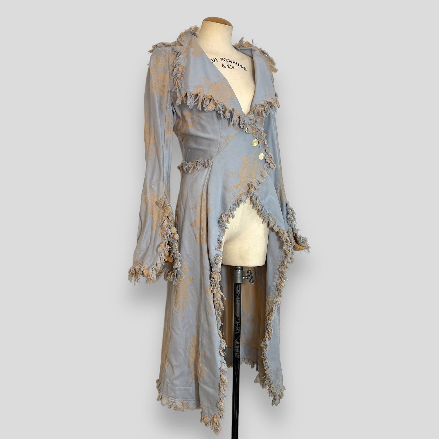 This exquisite coat, crafted from rose floral canvas and adorned with distressed fringe, is a standout piece from Vivienne Westwood's Spring 1998 