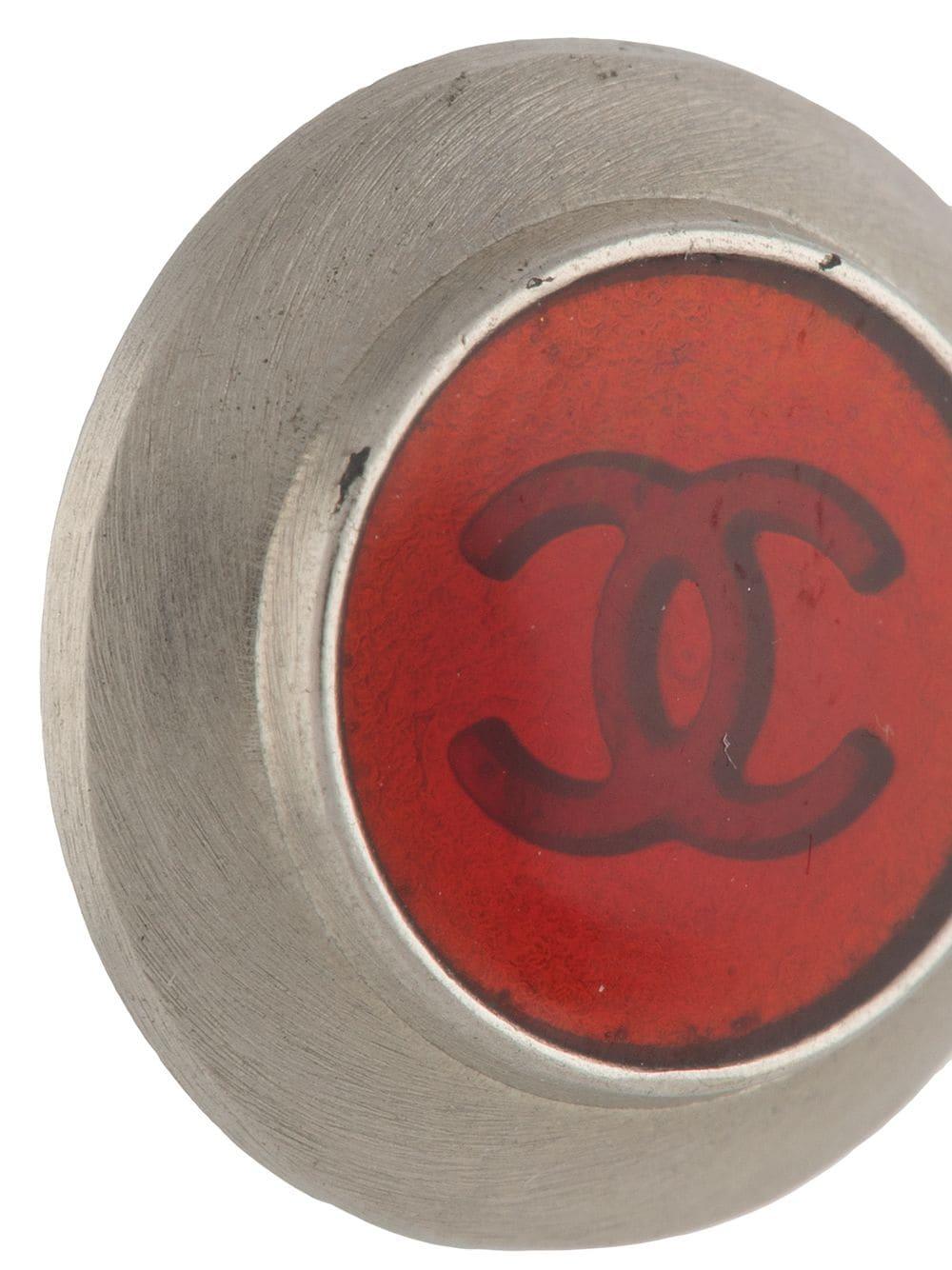 1998s Chanel red earrings featuring  a palladium outline, round logo shape and a logo back plaque.
Diameter: 0.6in (1.5cm)
In excellent vintage condition. Made in France. 
 We guarantee you will receive this gorgeous item as described and showed on