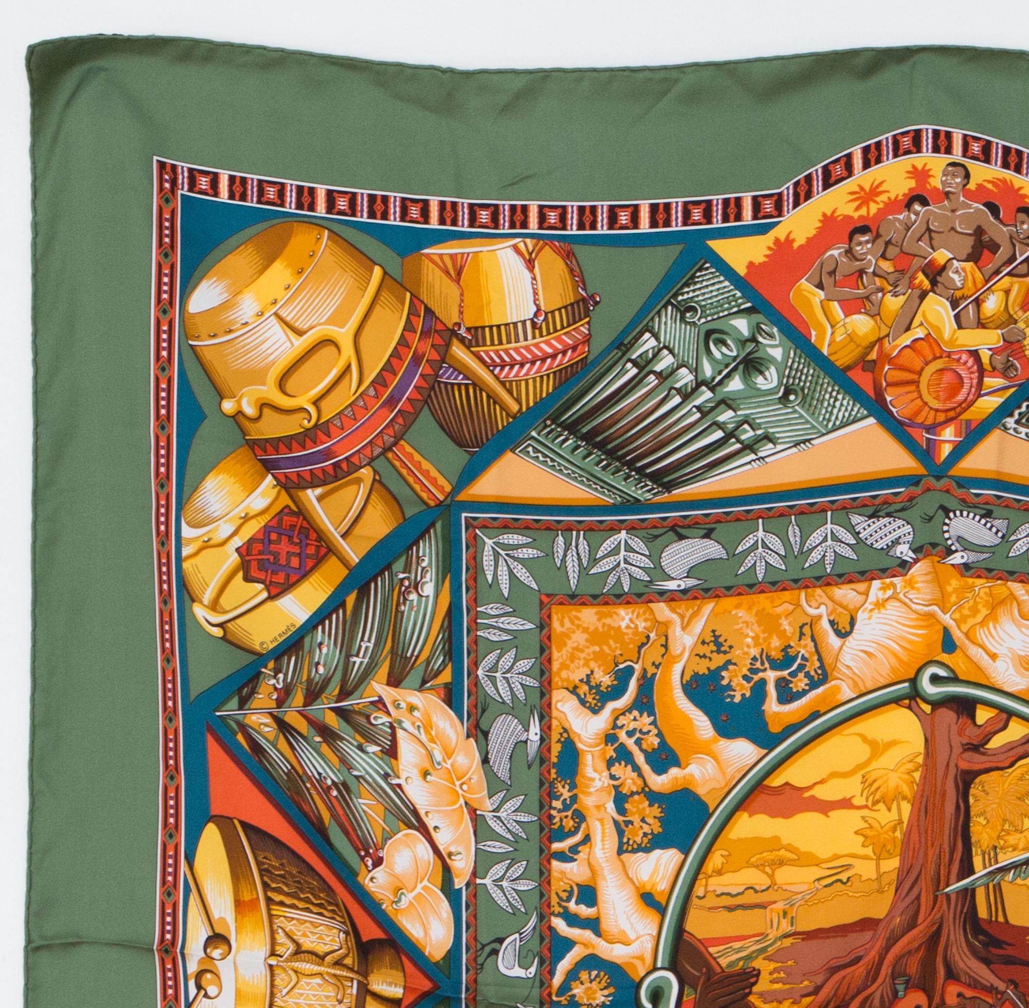 1998s Hermes silk scarf Au Son du Tam Tam by Laurence Bourthoumieux Toutsy from Hermès Vintage featuring a scene celebrating the sounds of African drums, and a kaki border.
In excellent vintage condition. Made in France.
35,4in. (90cm) X 35,4in.