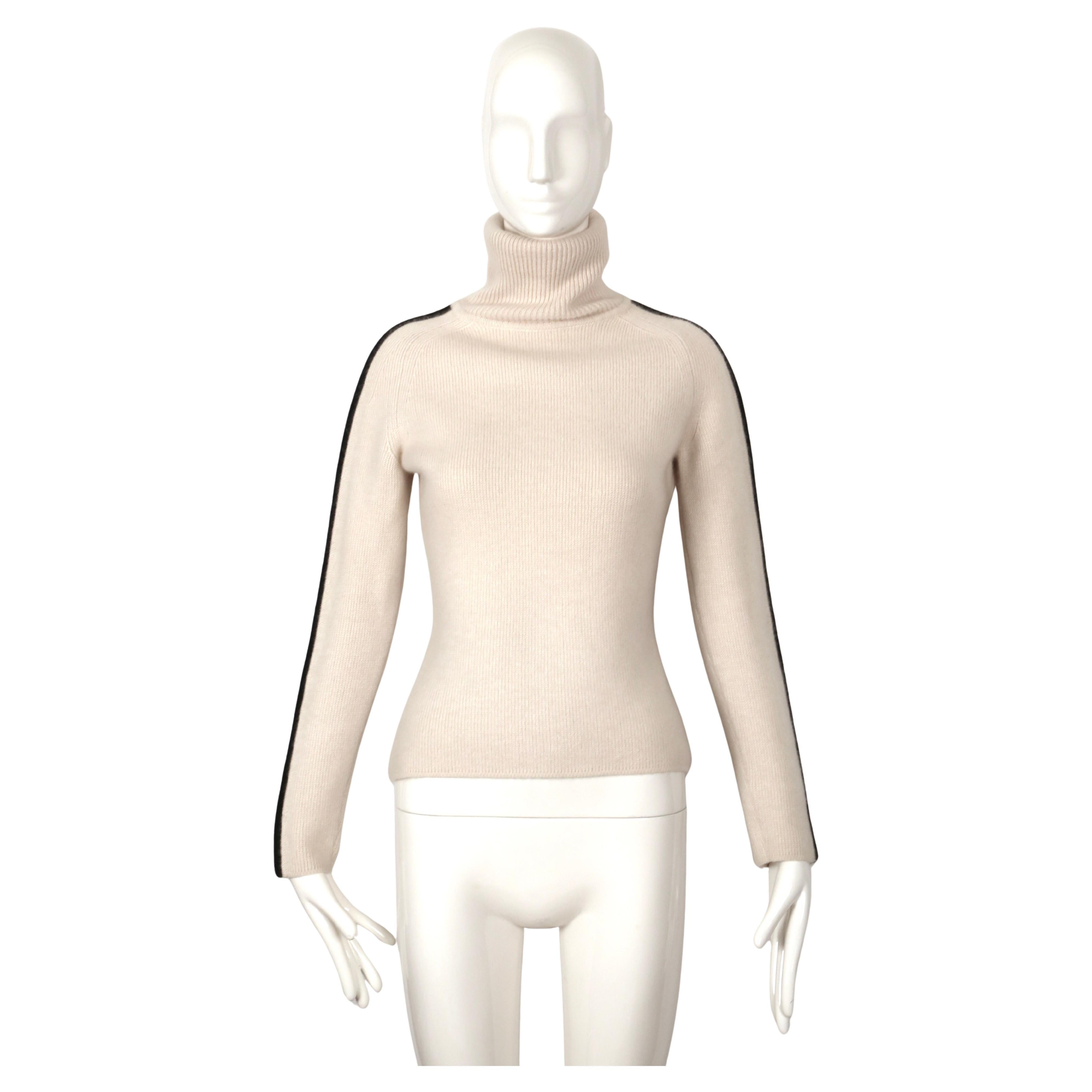 Very rare cream and black cashmere turtleneck with Celine logo on sleeves as worn by Gisele for a Celine ad campaign dating to fall of 1999.  Size M. Approximate measurements (unstretched): bust 34