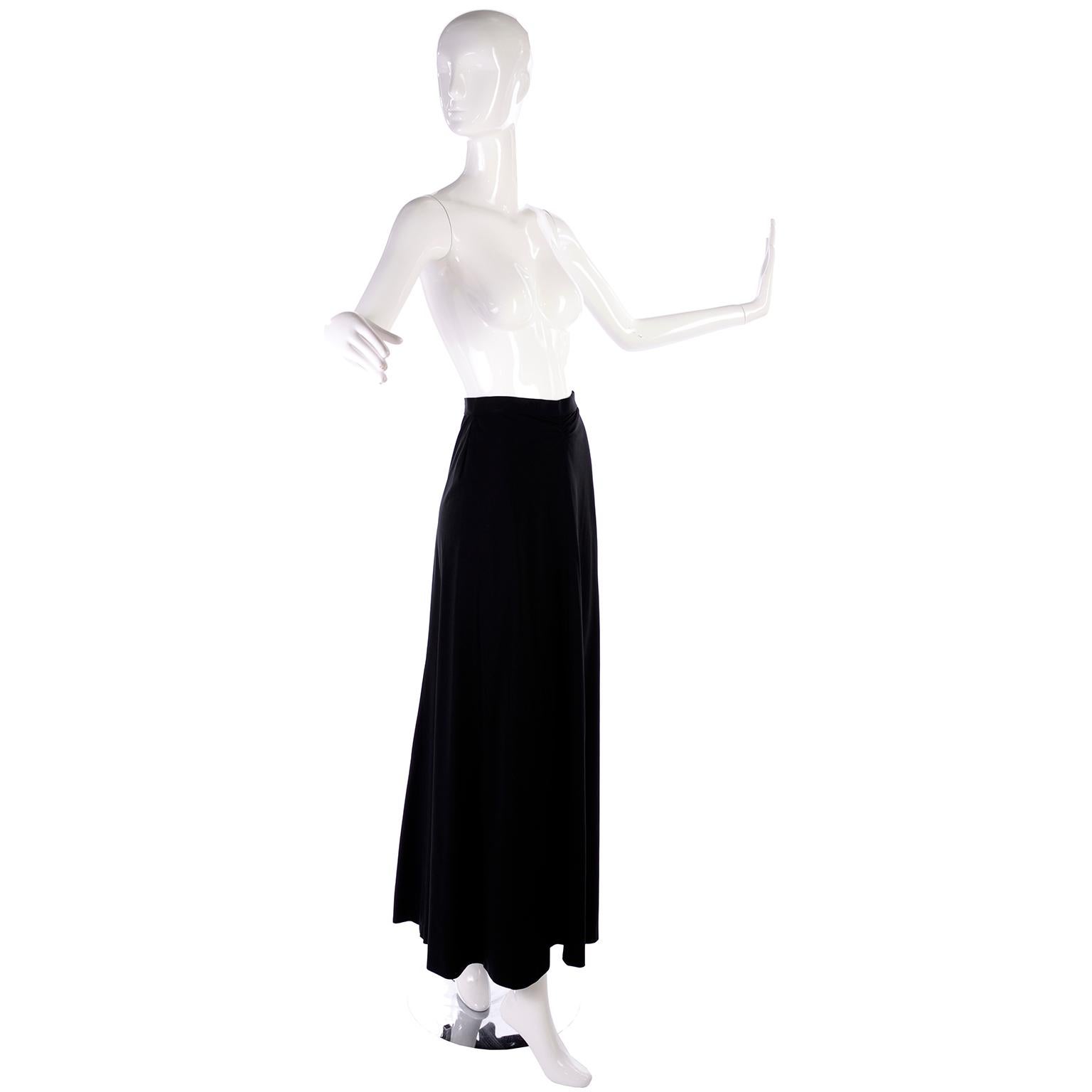 The perfect black maxi skirt from Chanel! From their 1999 Cruise collection, a blend of nylon, rayon and spandex for just enough stretch. The waist is fixed, and secured with a Chanel logo button and zipper in the back. The front has a unique subtle
