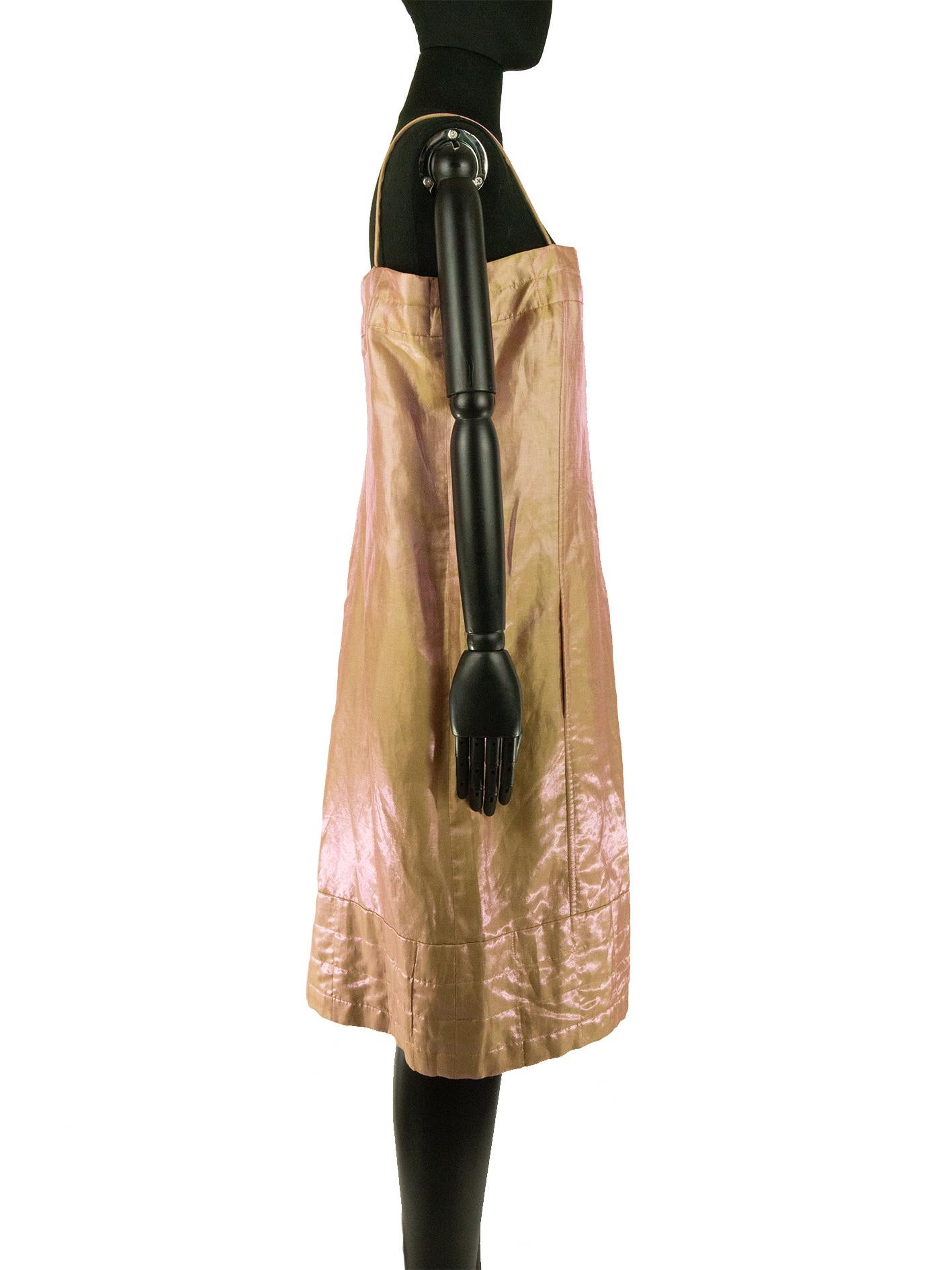 A Chanel sun dress in peach and metallic pink shot taffeta from the brand Spring 1999 collection. The reflective quality of the fabric makes the dress shift colour under movement. The dress has a straight neckline and is held up with spaghetti