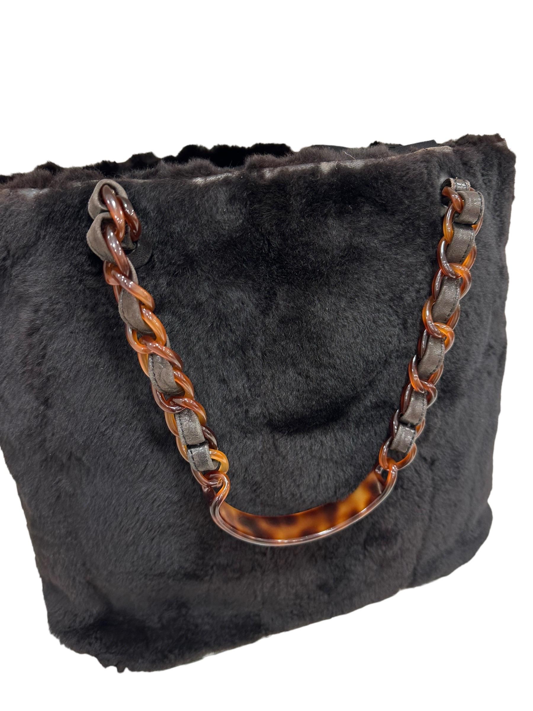 .Chanel Vintage shopper bag made with a dark brown fur with dark silver hardware. It has a large central opening equipped with a double magnetic button closure. The interior is lined with a smooth brown leather and is equipped with two pockets with