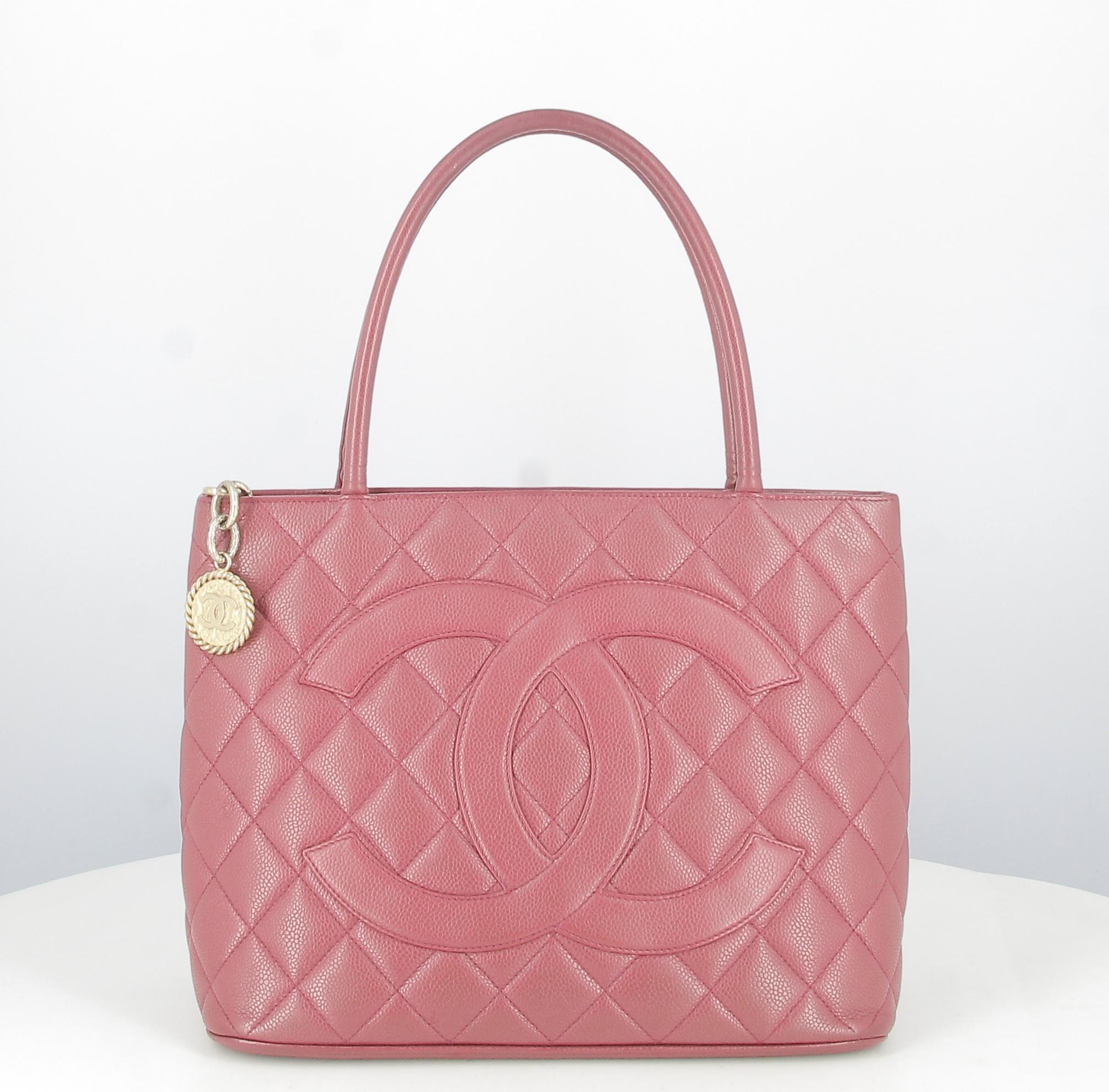 1999 Chanel Fushia Padded Leather Medallion Handbag 

- Very good condition. Shows signs of wear over time.
- Chanel Handbag 
- Medallion
- Colours : Fushia 
- Leather strap 
- Double C on the front
- Pocket on back of bag 
- Inside: leather and zip