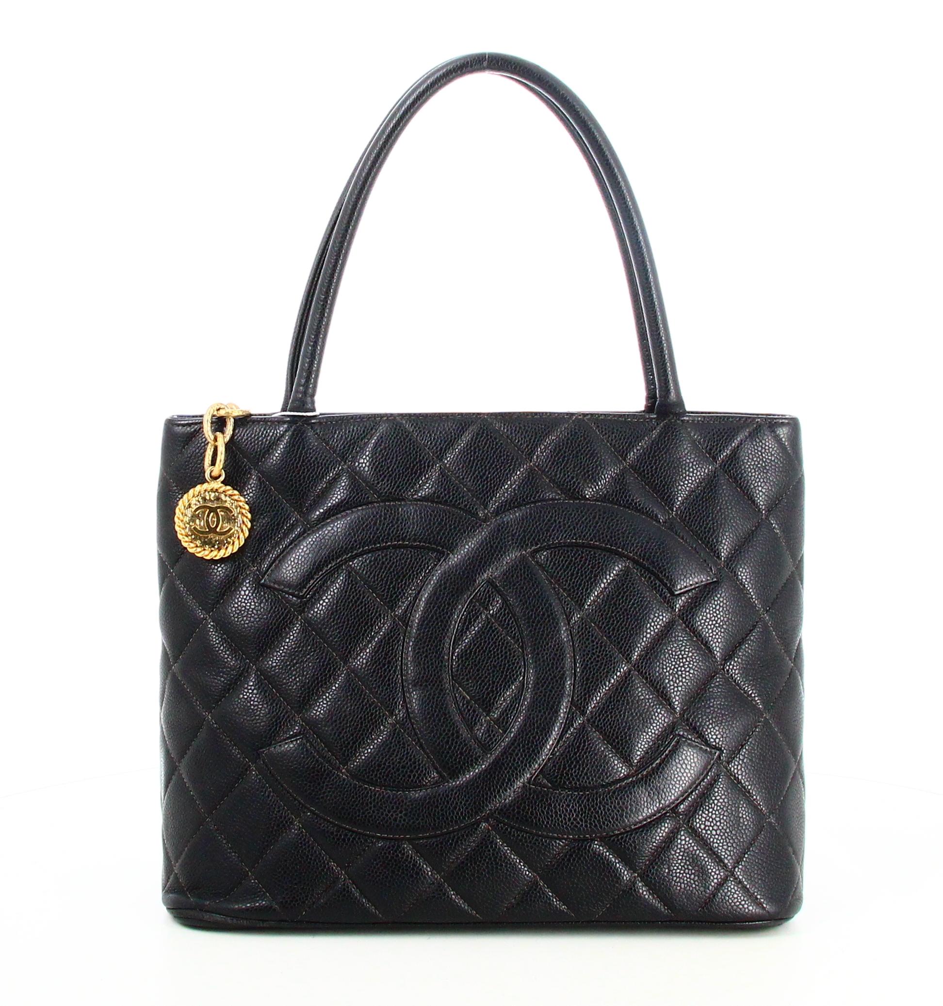 1999 Chanel Padded Black Leather Medallion Handbag 

- Good condition. Shows slight signs of wear over time. 
- Chanel Medallion Bag 
- Quilted black leather
- Two black leather straps 
- Golden chain medallion 
- Double C logo on front 
- Interior: