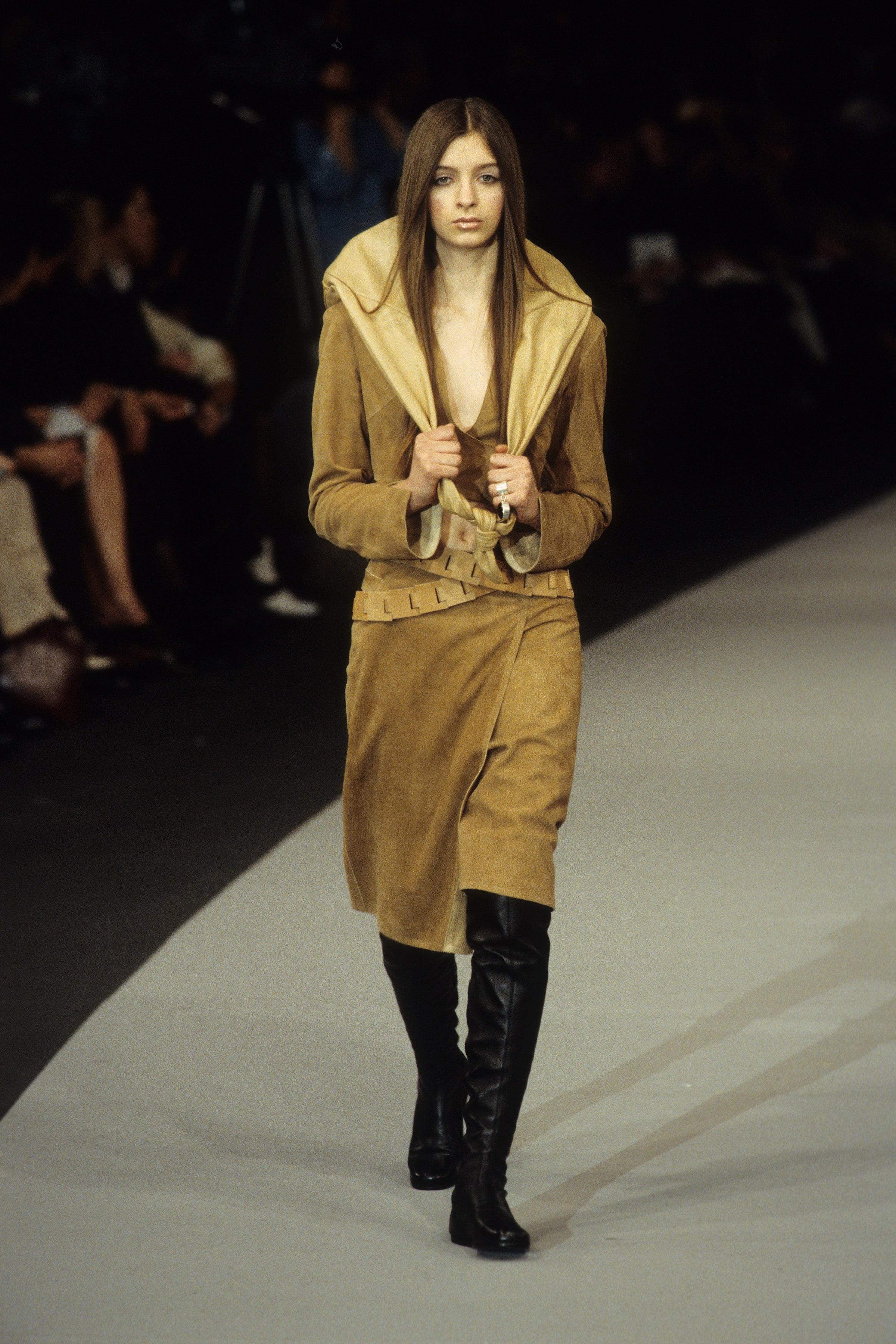 Introducing the exquisite 1999 Chanel Runway Tan Suede Lambskin Long-Sleeve Wrap Top and Skirt Set—an epitome of luxury and timeless elegance. This stunning ensemble features a beautifully tailored wrap top that effortlessly accentuates the waist,