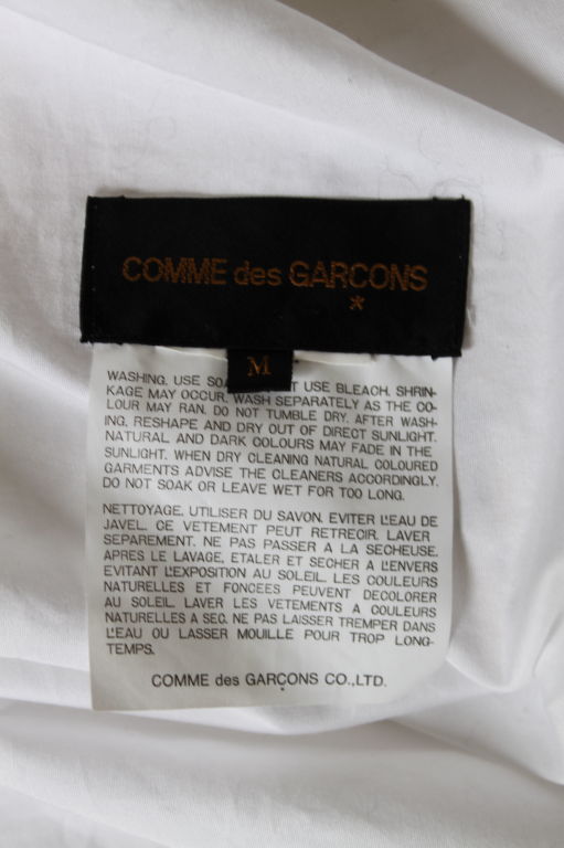 Unique white cotton wrap top with lace trim from Comme Des Garcons dating to the fall of 1999 exactly as seen on the runway. Can be worn open as a jacket or secured with a pin at waist. Jacket is labeled a 'M' but fits a size small or medium. Made