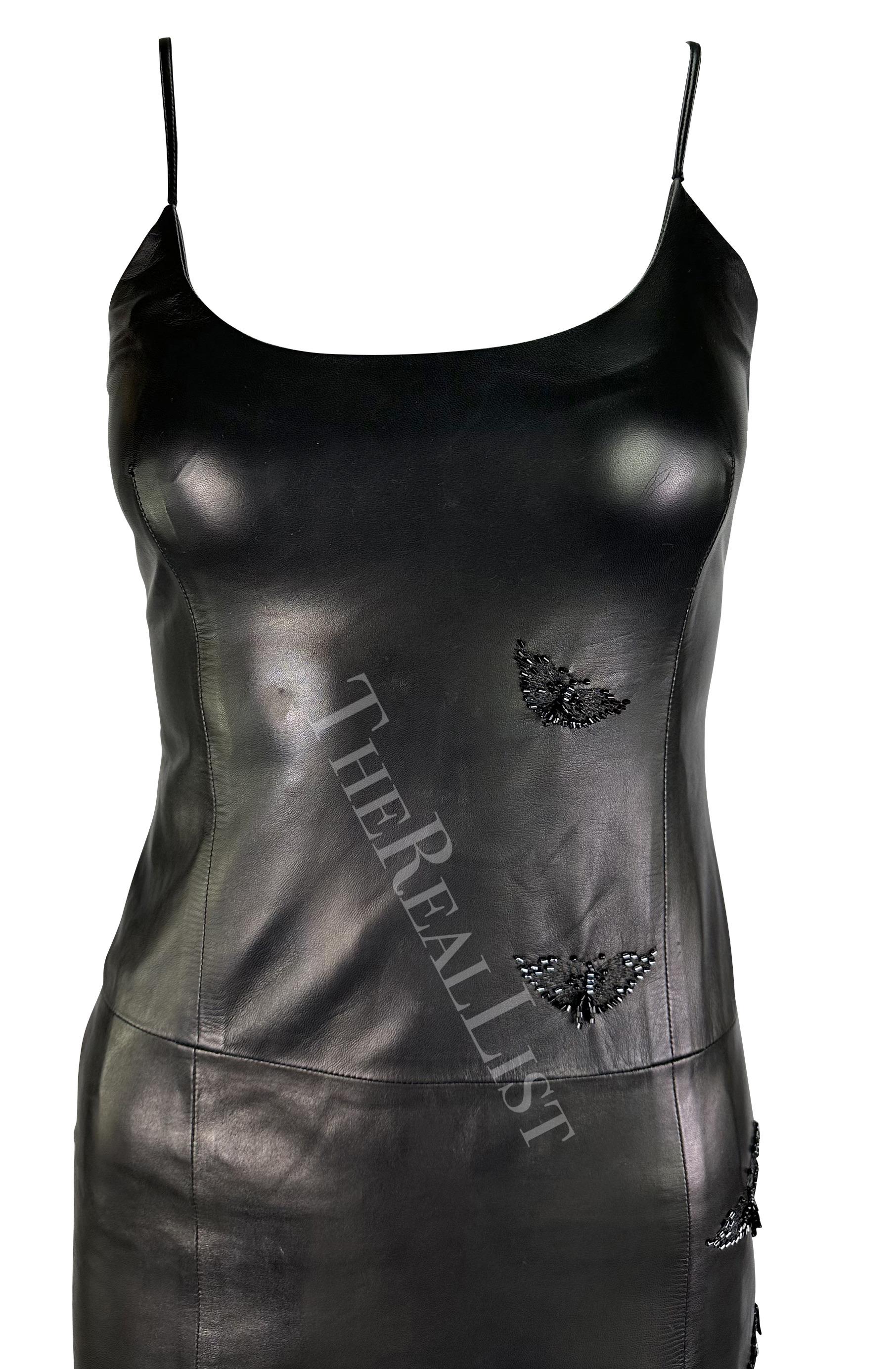 Presenting an incredible black leather Gianni Versace mini dress, designed by Donatella Versace. From 1999, this sexy dress is constructed entirely of leather and is made complete with a beaded butterfly design on one side. The dress features a wide