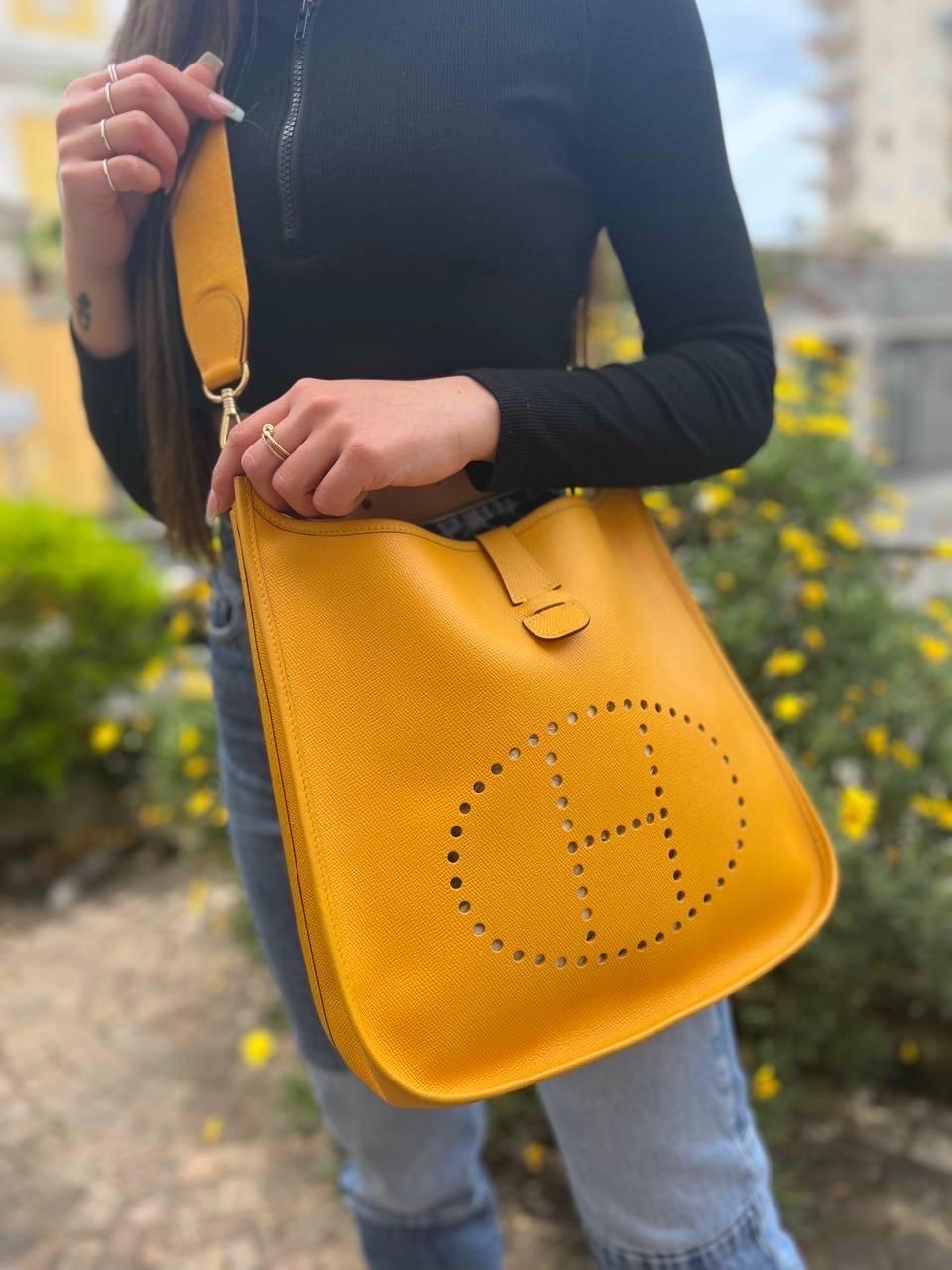 Bag signed Hermès, model Evelyne, size Gm, made in Epsom leather, stiff and structured with motif printed in the leather, in the Jaune colorway with golden hardware. Equipped with a closure with a central button band, internally lined in yellow