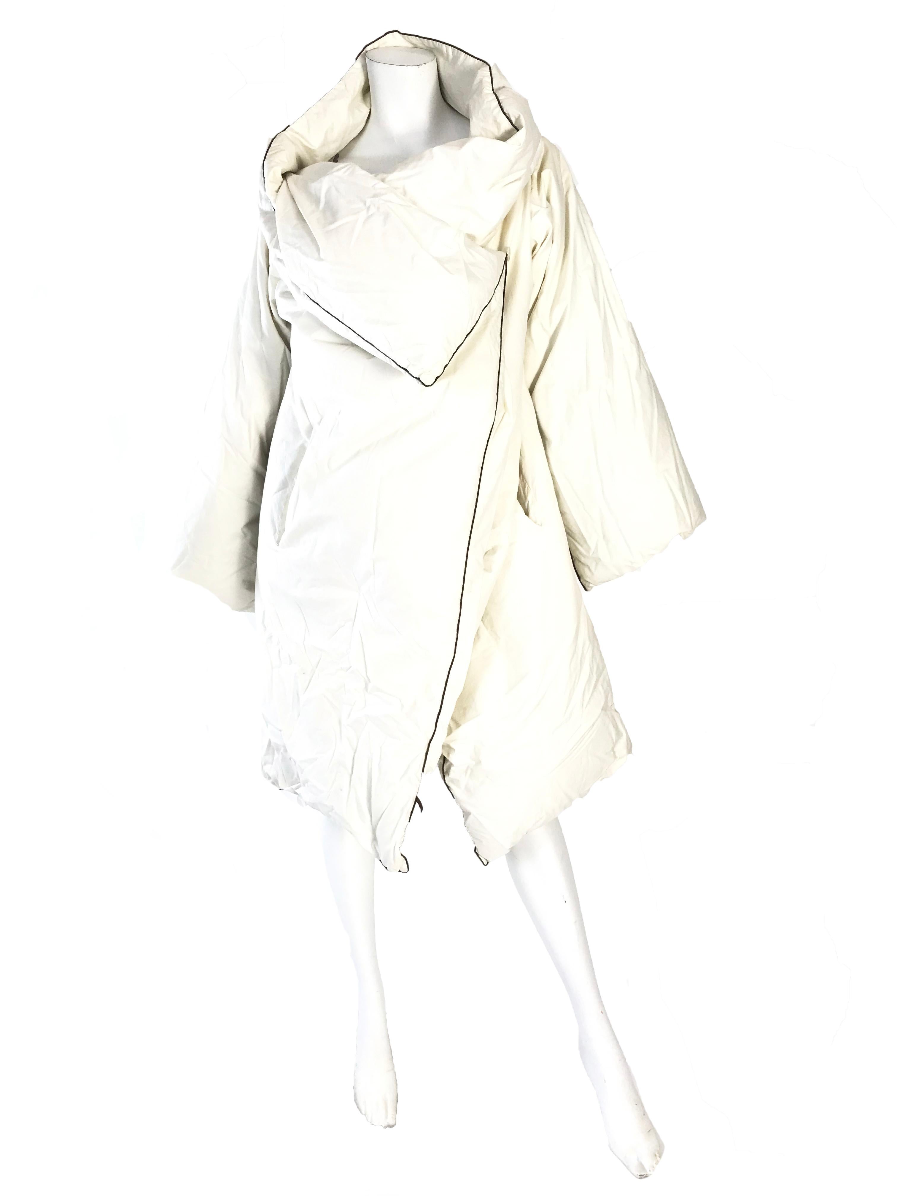 1999 Maison Martin Margiela Iconic Artisanal Duvet Coat. Hergestellt aus einer Featherlite-Bettdecke mit 100% Daunenfüllung. Off-white Farbe mit braunem Rand:: abnehmbare Reißverschluss Ärmel. Zustand: Ausgezeichnet
Einheitsgröße