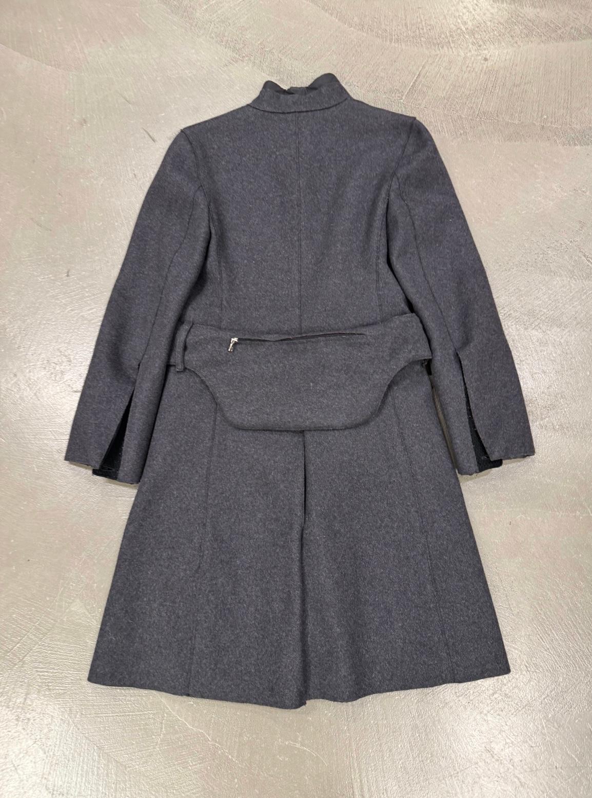 1999 Prada, cappotto in lana con tasche cargo tecniche e cintura

Questo cappotto in lana di Prada del 1999 unisce perfettamente raffinatezza e dettagli utilitaristici. Realizzato in pregiata lana grigio scuro, presenta un elegante design a collo