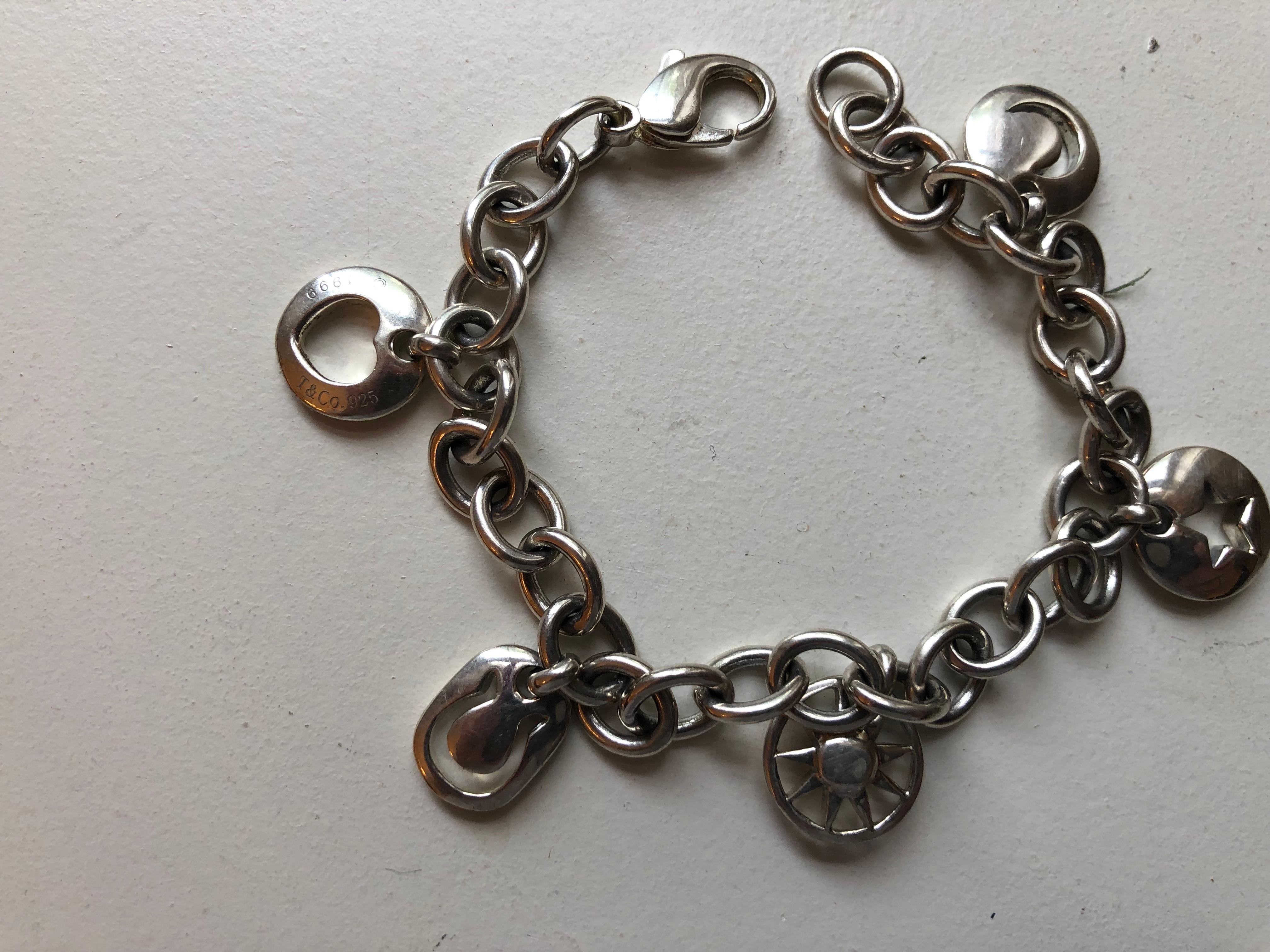 This silver Tiffany charm bracelet has five stencil charm bracelet, and can be worn on a daily basis. The bracelet is very comfortable and in very good condition. The piece is hallmarked, and T & Co along with the silver content 925 is stencilled on