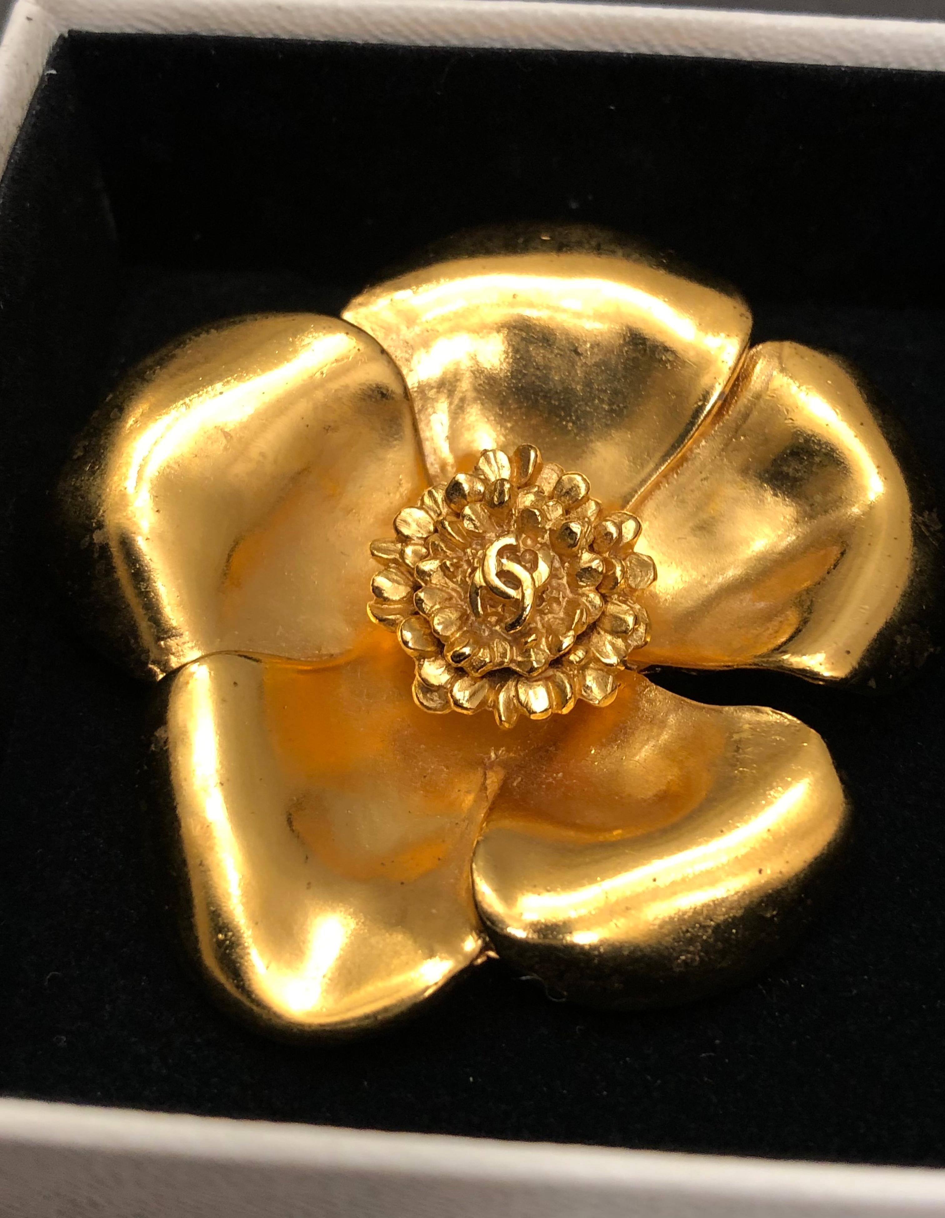 This vintage CHANEL camellia brooch is crafted of gold toned metal featuring a CC logo at the center. Stamped CHANEL 99P made in France. Measures approximately 5.2 cm in diameter at the widest points. Comes with box. 

Condition: Very good vintage