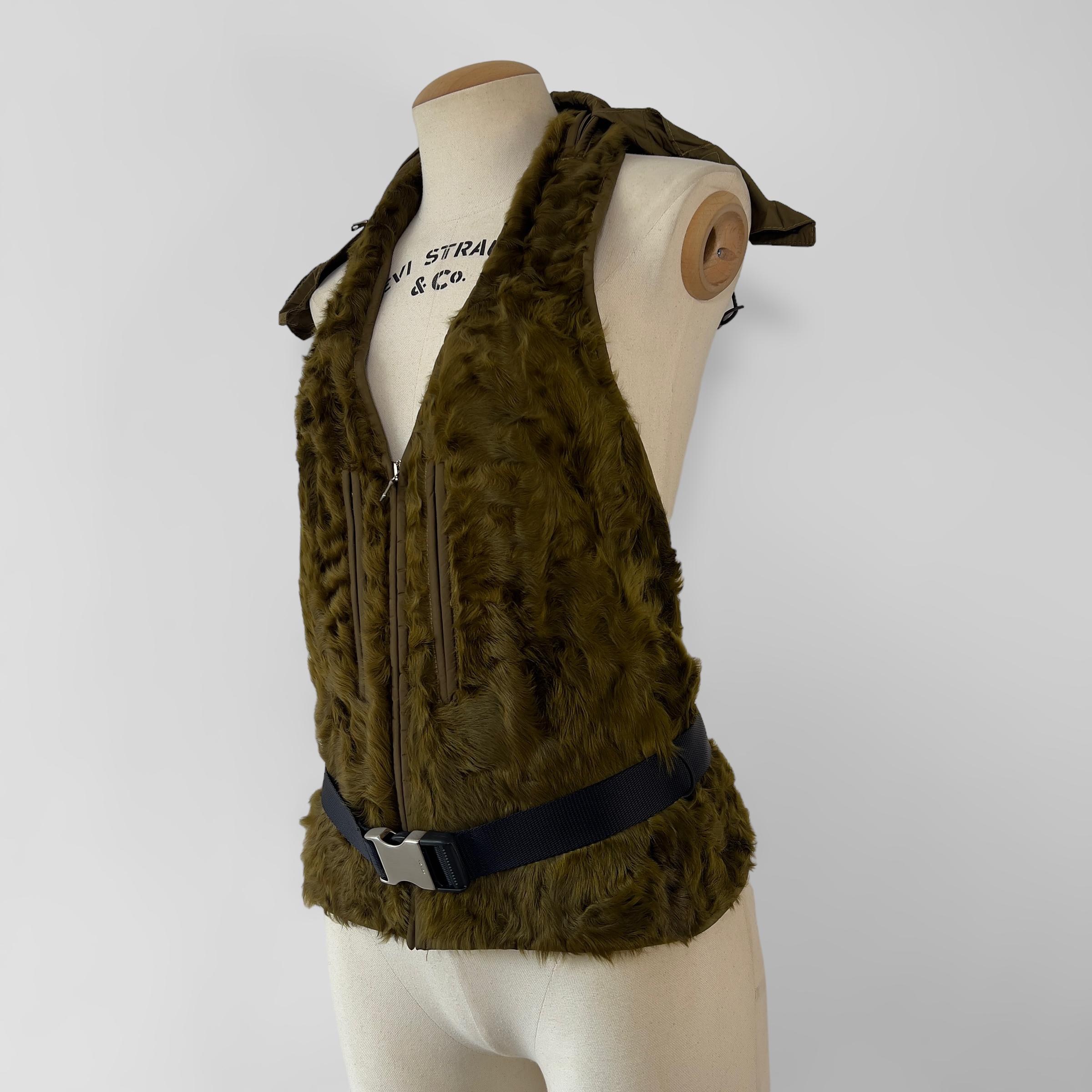 Vintage Prada runway lamb backless waistcoat with nylon buckle belt and nylon hood.  Fall-Winter 1999

Size: IT 42.

`Condition: very good with minimal to no fur loss. 