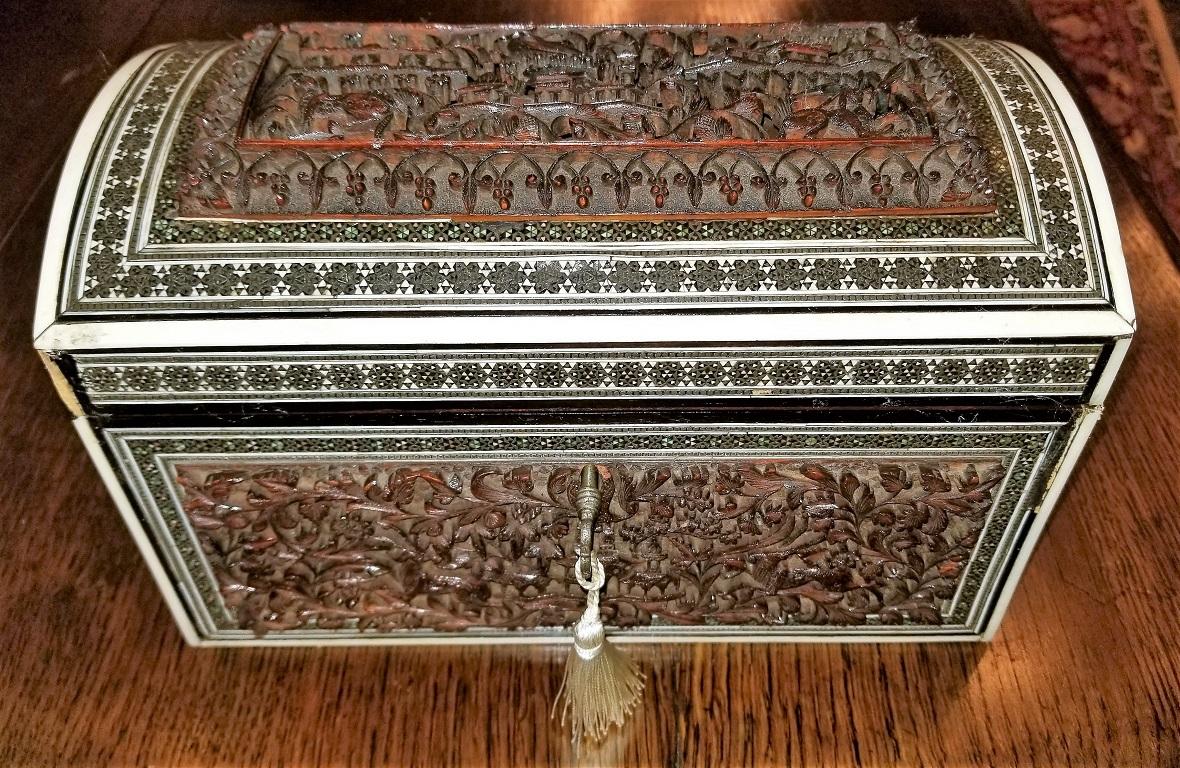 Gorgeous 19th century Anglo-Indian double tea caddy, from circa 1880.

The caddy is made from sandalwood encased in highly carved Padouk wood with deep reliefs and fretwork on the lid.
It is edged in faux ivory, ebony and sadeli mosaic.
Made in