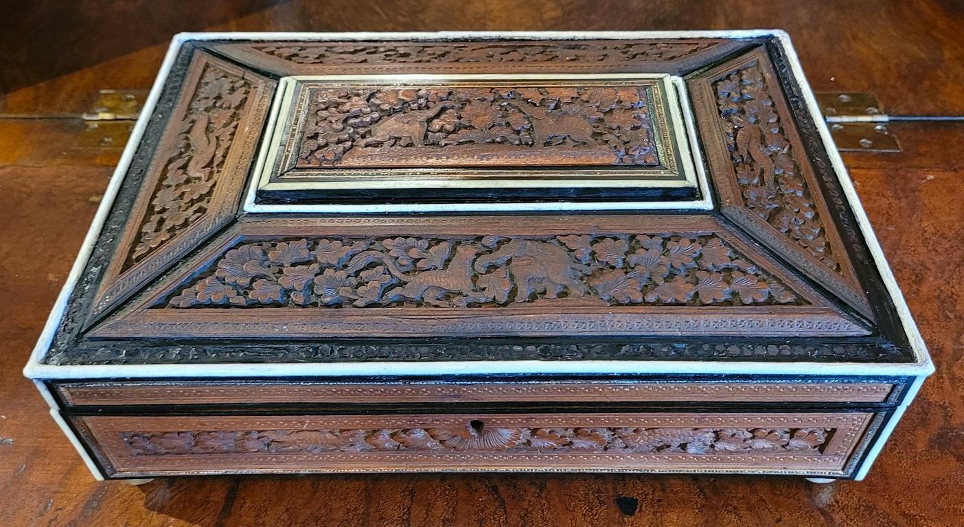 PRESENTING A VERY NICE 19C Anglo Indian Highly Carved Padouk and Sandalwood Sarcophagus Sewing Box.

Made in Bombay, India circa 1890-1900.

The box case/body is made of sandalwood with highly carved padouk wood reliefs and panels on all sides.