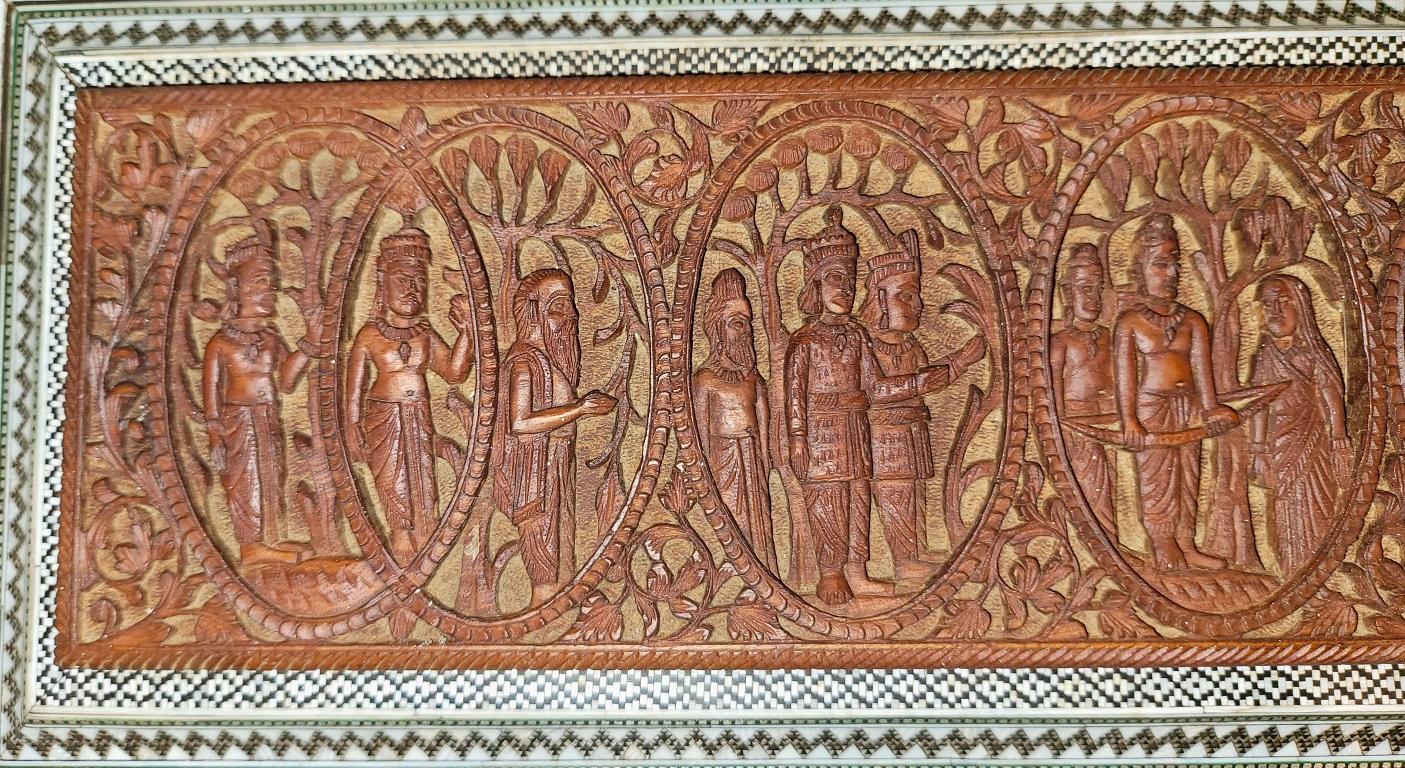 PRÉSENTE UNE EXCEPTIONNELLE ET ABSOLUMENT ÉCLATANTE boîte à rouleaux en mosaïque Padouk Sadeli de l'époque anglo-indienne du 19e siècle, fortement sculptée et représentant des dieux hindous, datant d'environ 1870-80.

Le coffret est en bois de