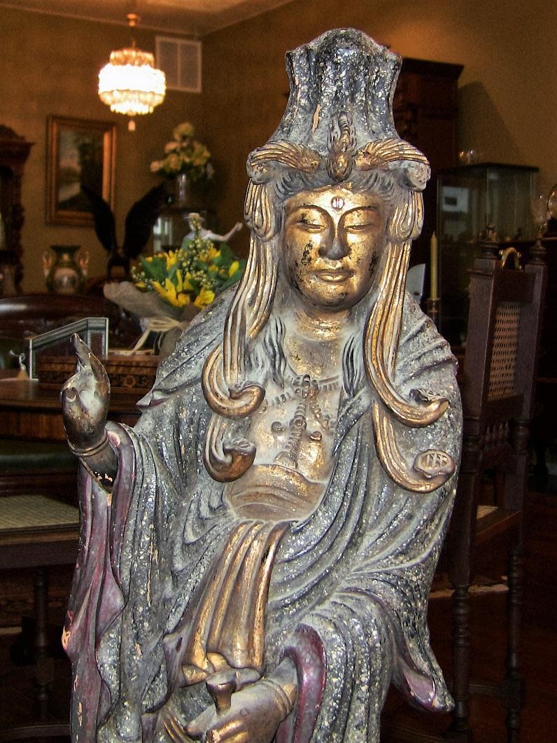 Wir präsentieren eine beeindruckende, aus Holz geschnitzte, bemalte und vergoldete asiatische Guanyin-Statue aus dem 19.

Diese Holzstatue ist handgeschnitzt, handbemalt und handvergoldet.

Es stellt die buddhistische Göttin 