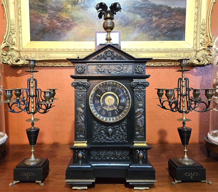 PRESENTING A STUNNING Mid 19th Century French Slate & Bronze Mantel Clock by Marti with pair of slate and bronze candelabra’s as garnitures.

This ‘large’ mantle clock, was made circa 1860, by the famous French and Parisienne Clockmaker – ‘J. Marti