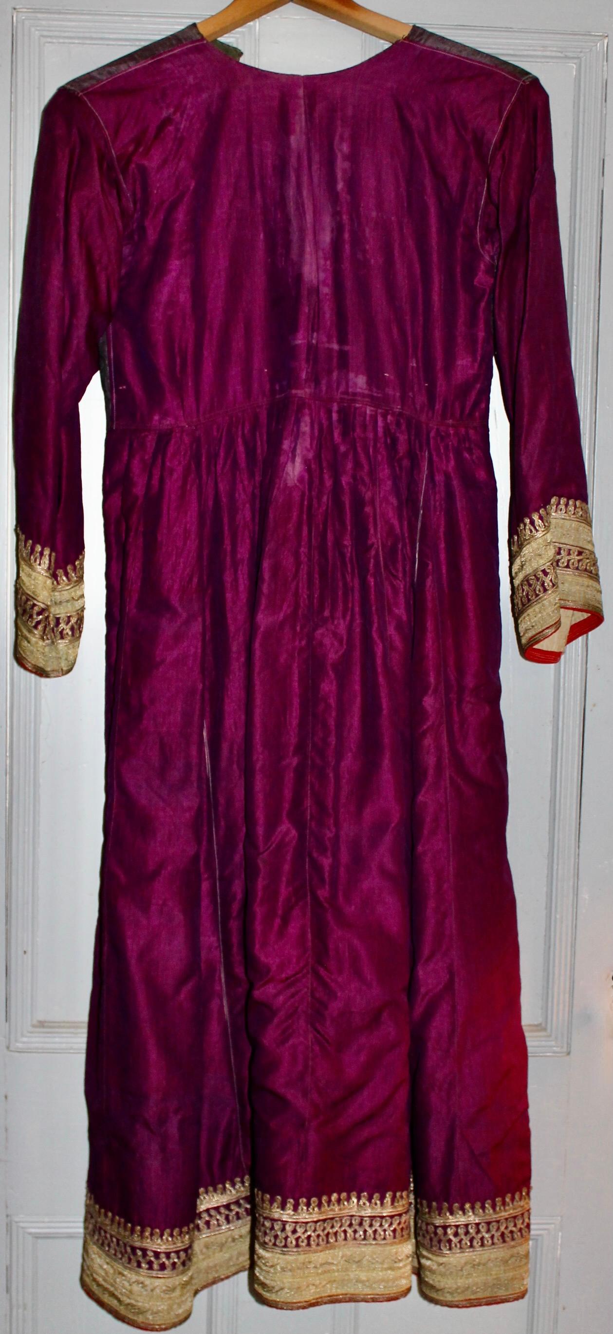 Hand woven violet silk dress with gold braid appliqué decoration on hem and sleeve cuffs.  Fully lined in cotton and fine linen. Length of sleeve 20.5