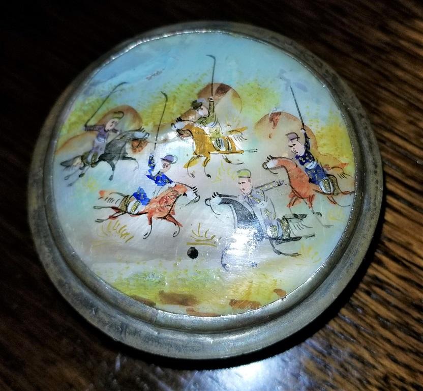Lovely early 19th century example of an Indo-Persian gilt metal and hand painted mother of pearl pill box featuring a polo game. From circa 1820.
Probably made in North India, but heavily Persian influenced.
The box is made of a gilt metal,
